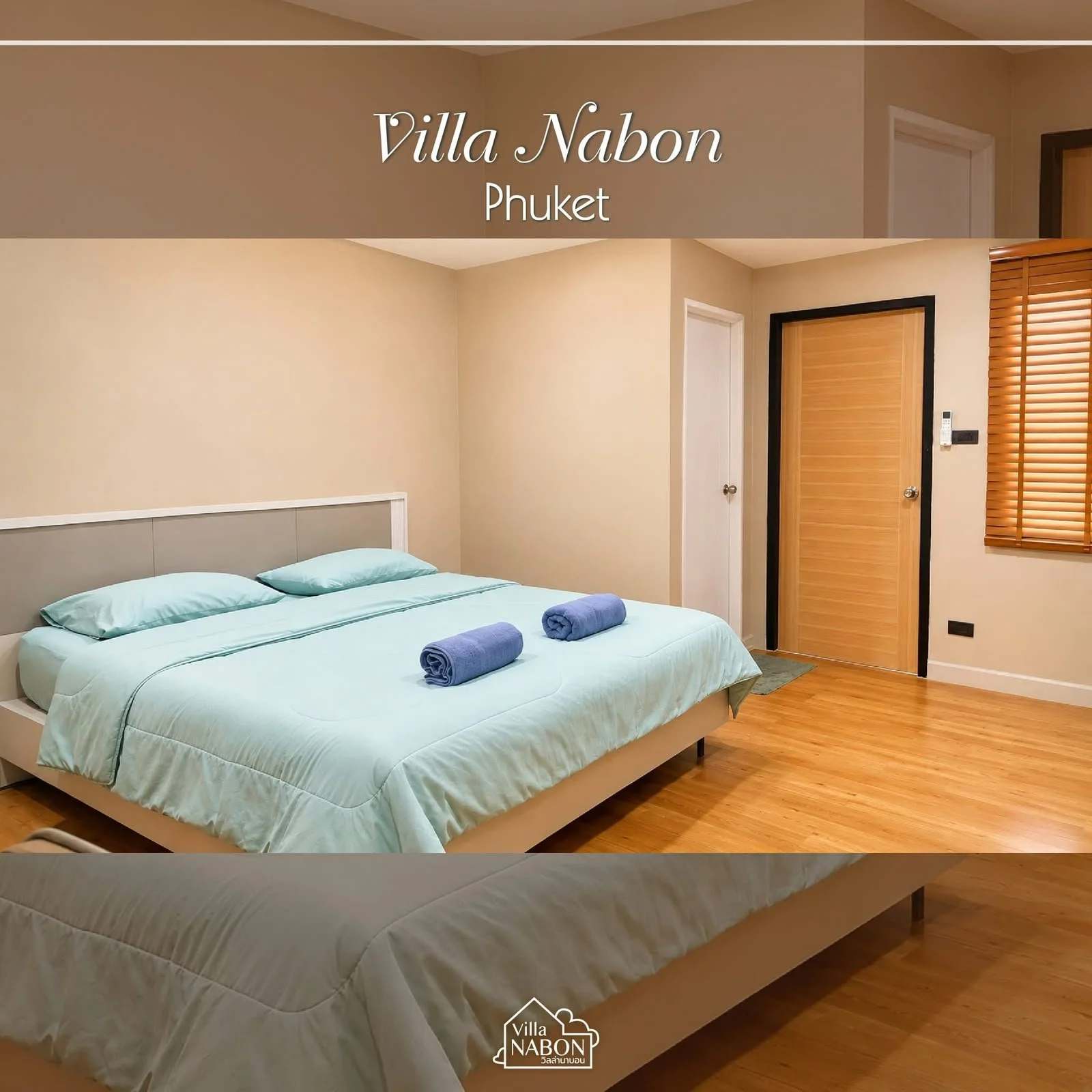 A bedroom with a bed, light blue bedding, two rolled towels, beige walls, a wooden door, a window with wooden blinds, and wooden flooring.