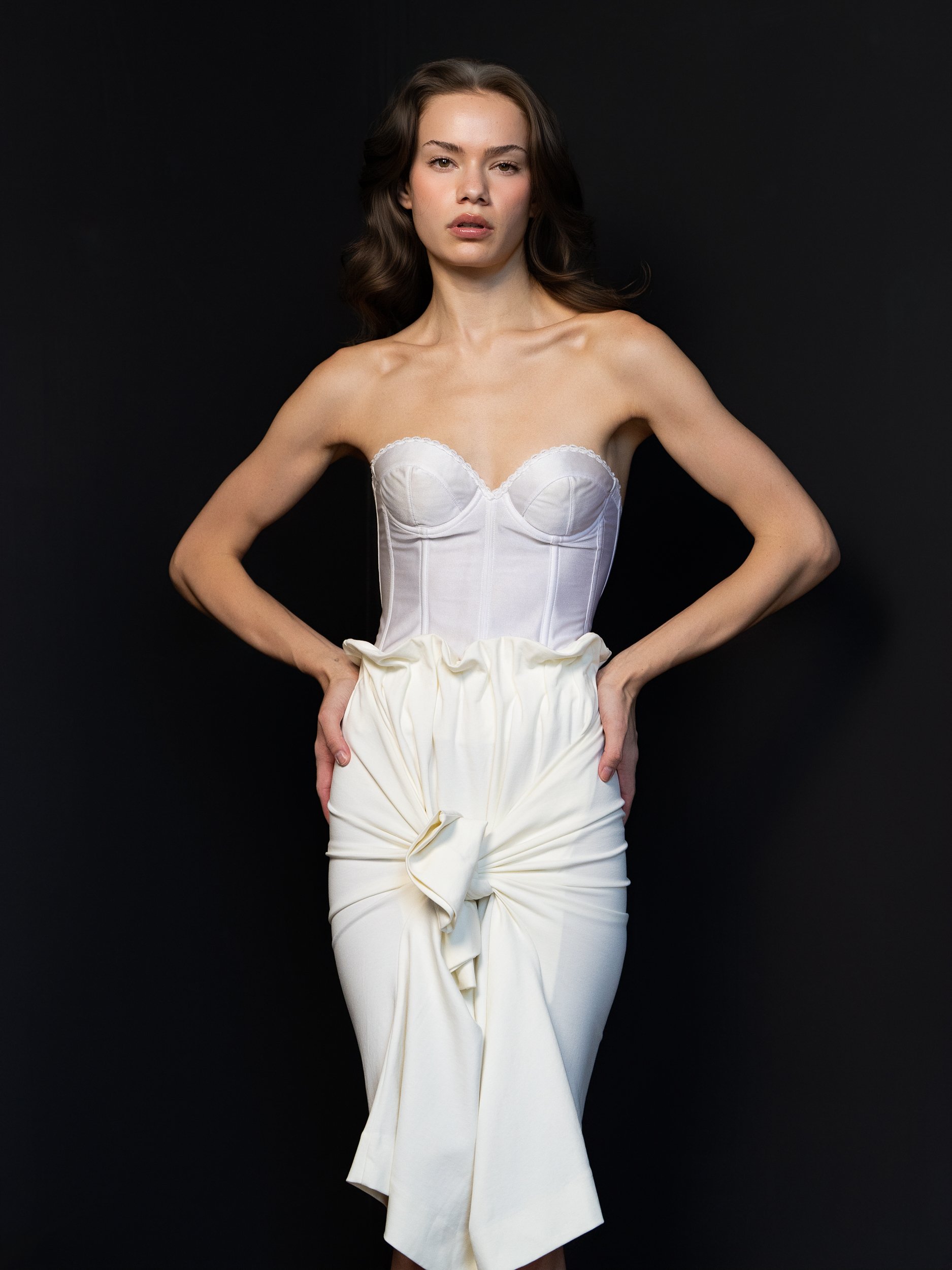 Madison with a level, composed gaze, dark hair and white top studio