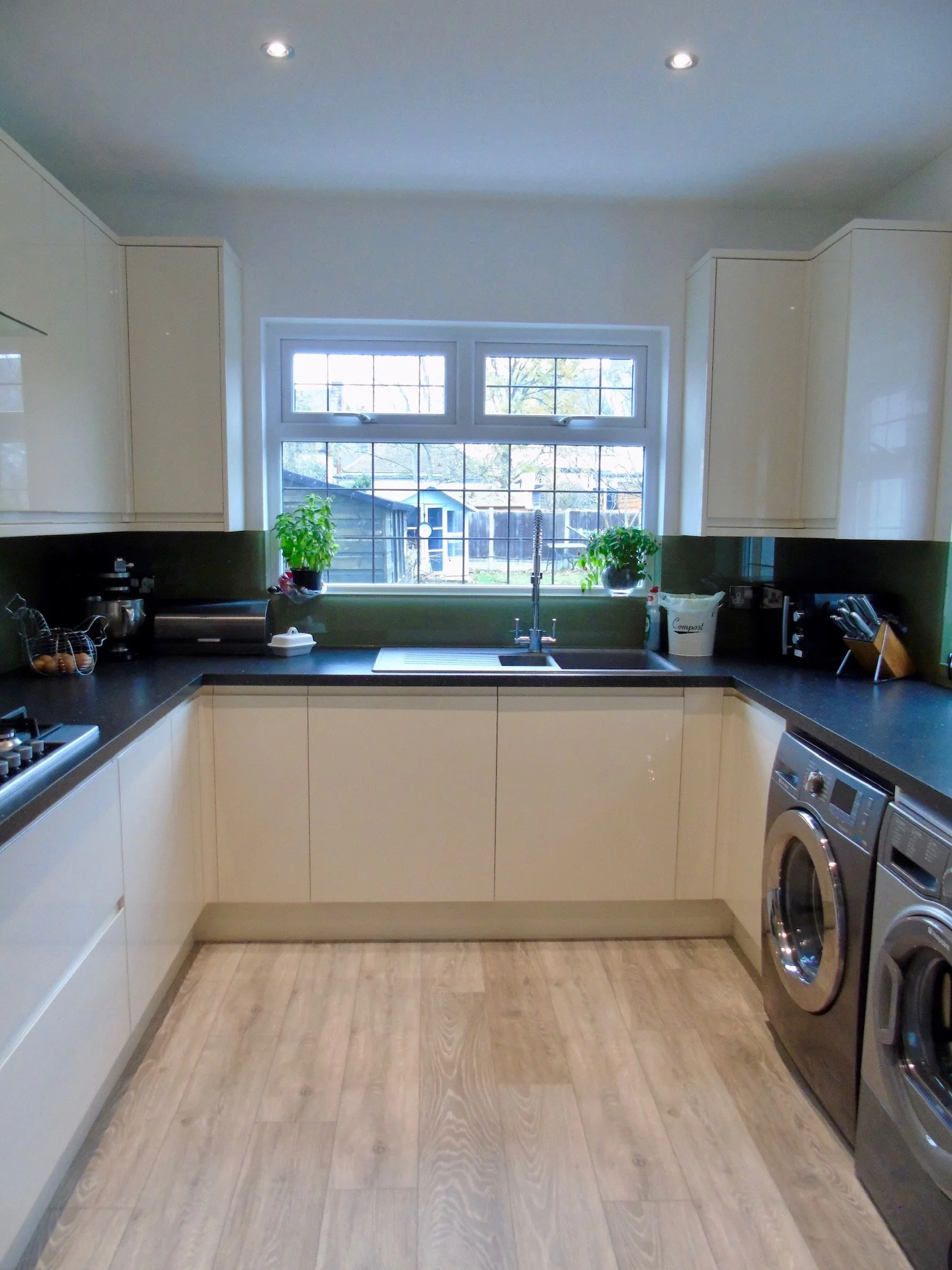 Cream gloss integrated handles with coloured glass splash back