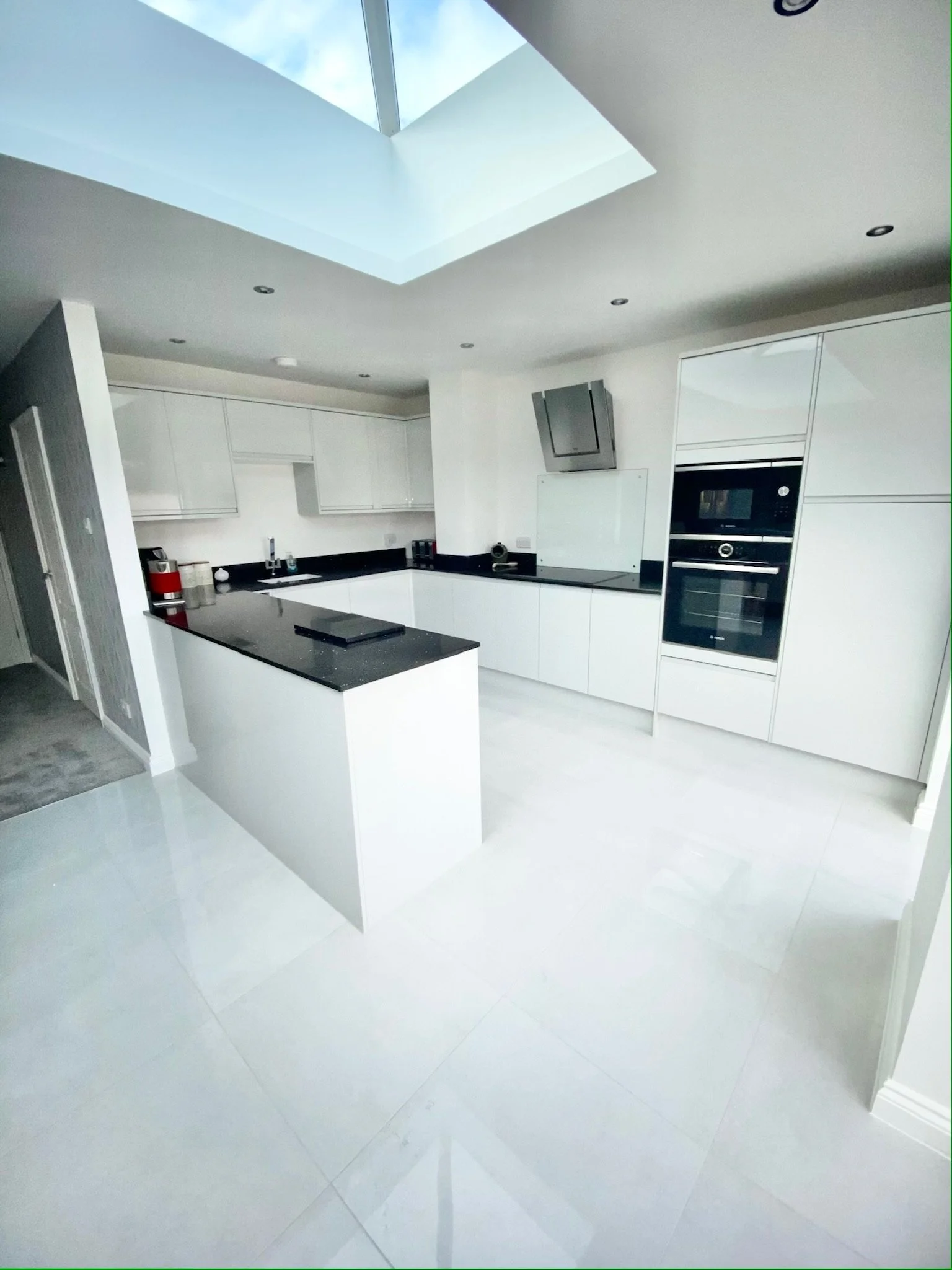 Handless gloss white kitchen with Granite worktops