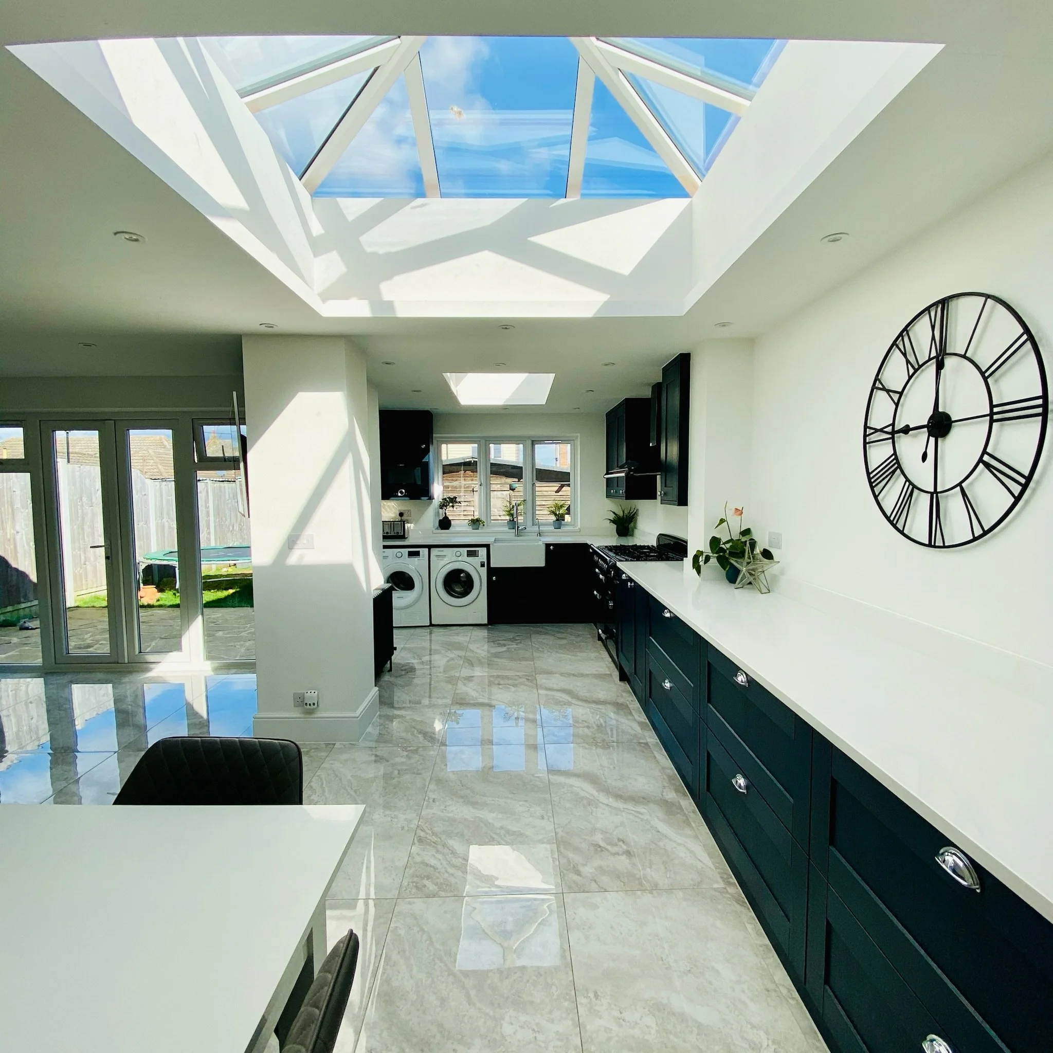 Navy blue shaker style with quartz worktops and butler sink