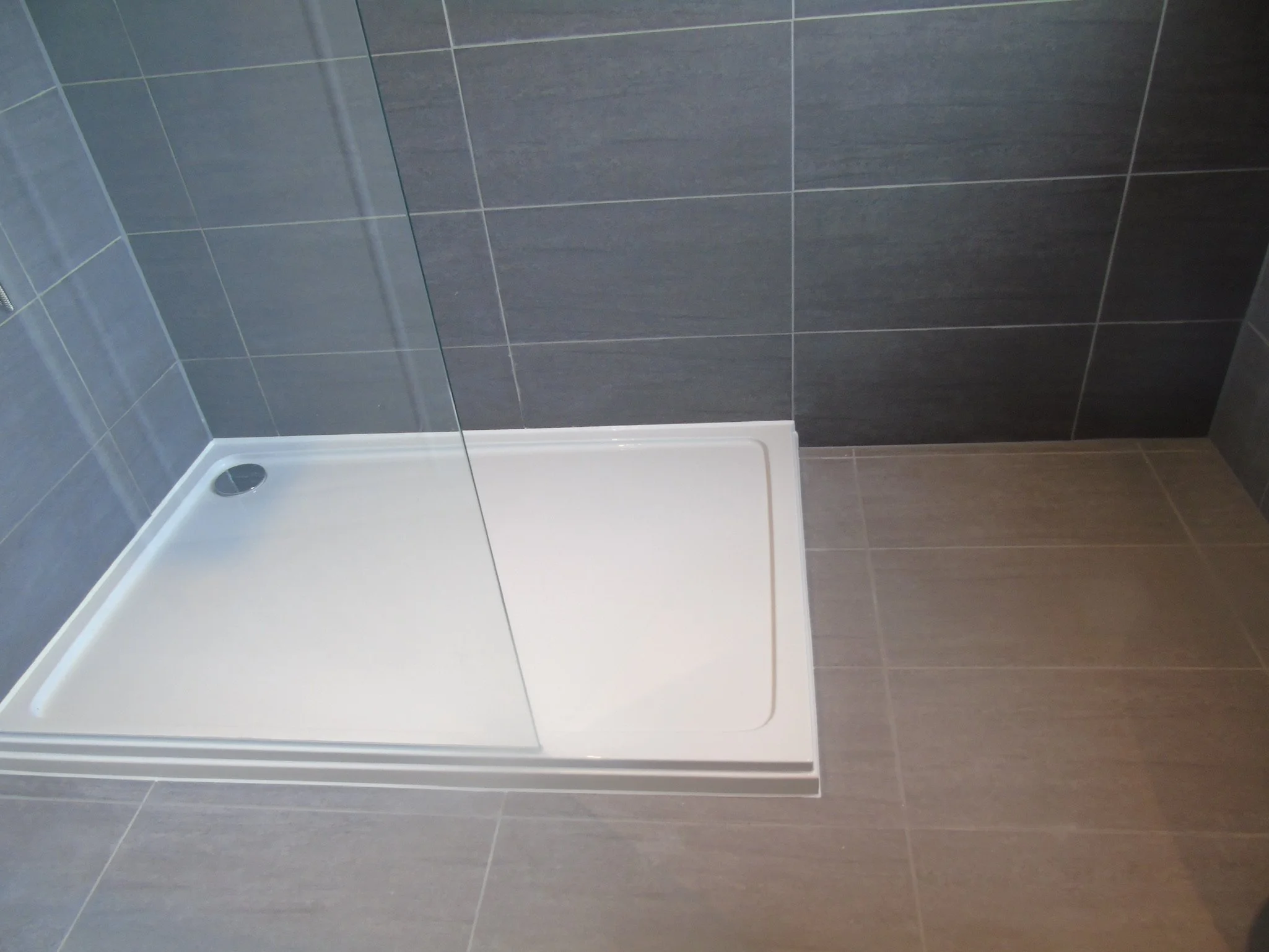 Walk in shower with low profile tray and fixed panel