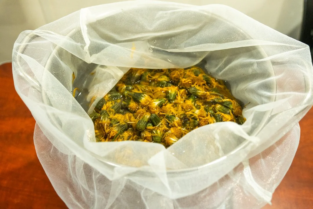 A pot with dried arnica flowers inside.