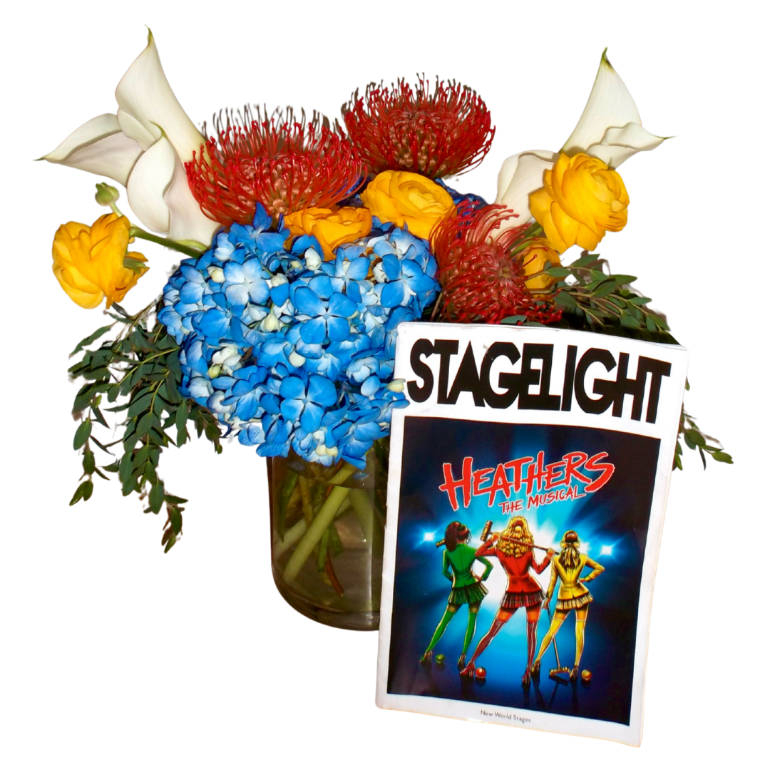 Flowers in a vase with a StageLight sign and a Heather's The Musical poster.