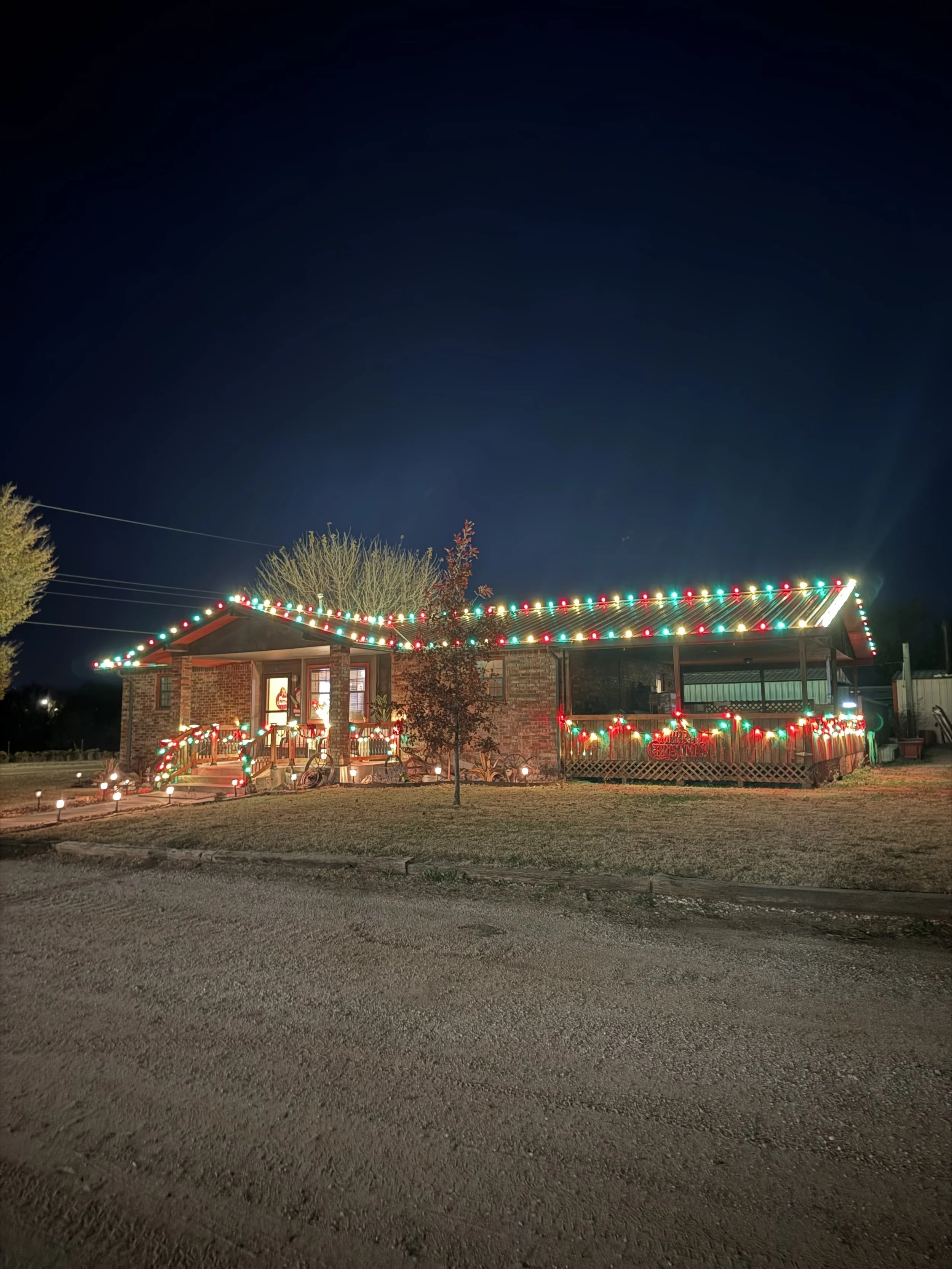 Residential Christmas light installation in Fort Worth Texas. Red, green and warm white roofline lighting and entrance lighting by Bearded Elf Co.