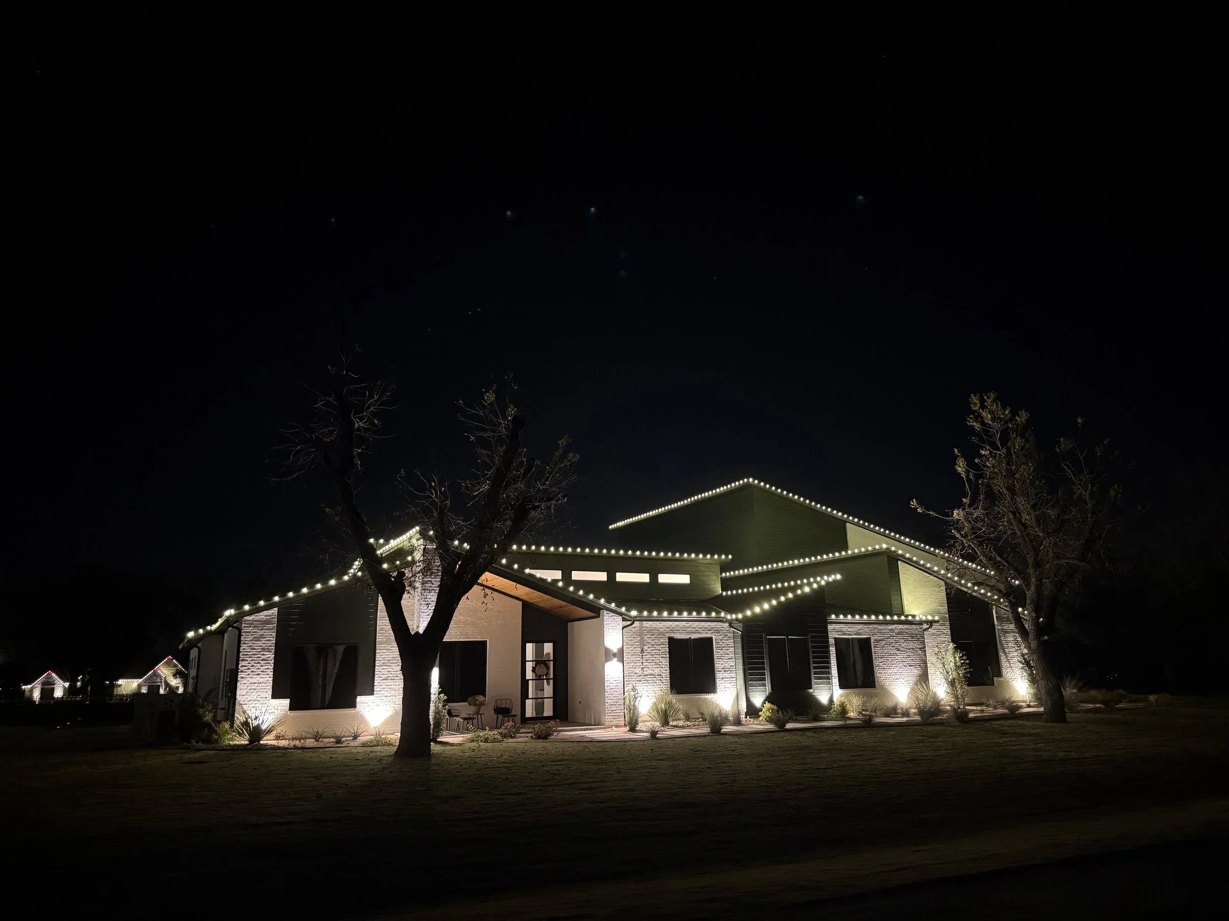 Modern home and Airplane Hanger Christmas light installation in Granbury Texas. Clean roofline lighting on contemporary custom home by Bearded Elf Co.