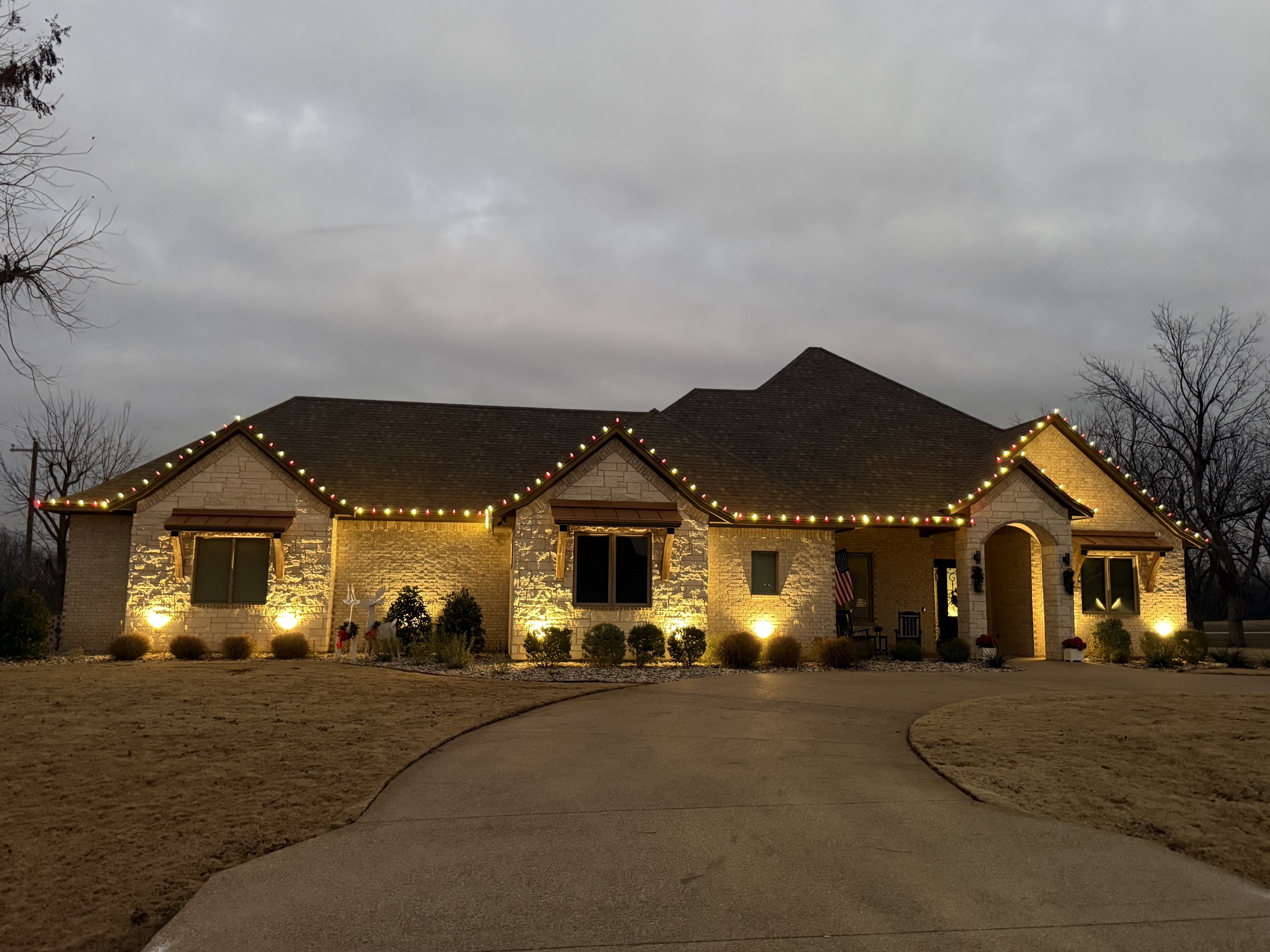 Residential Christmas light installation in Aledo Texas. Red, and warm white roofline lighting and entrance lighting by Bearded Elf Co.