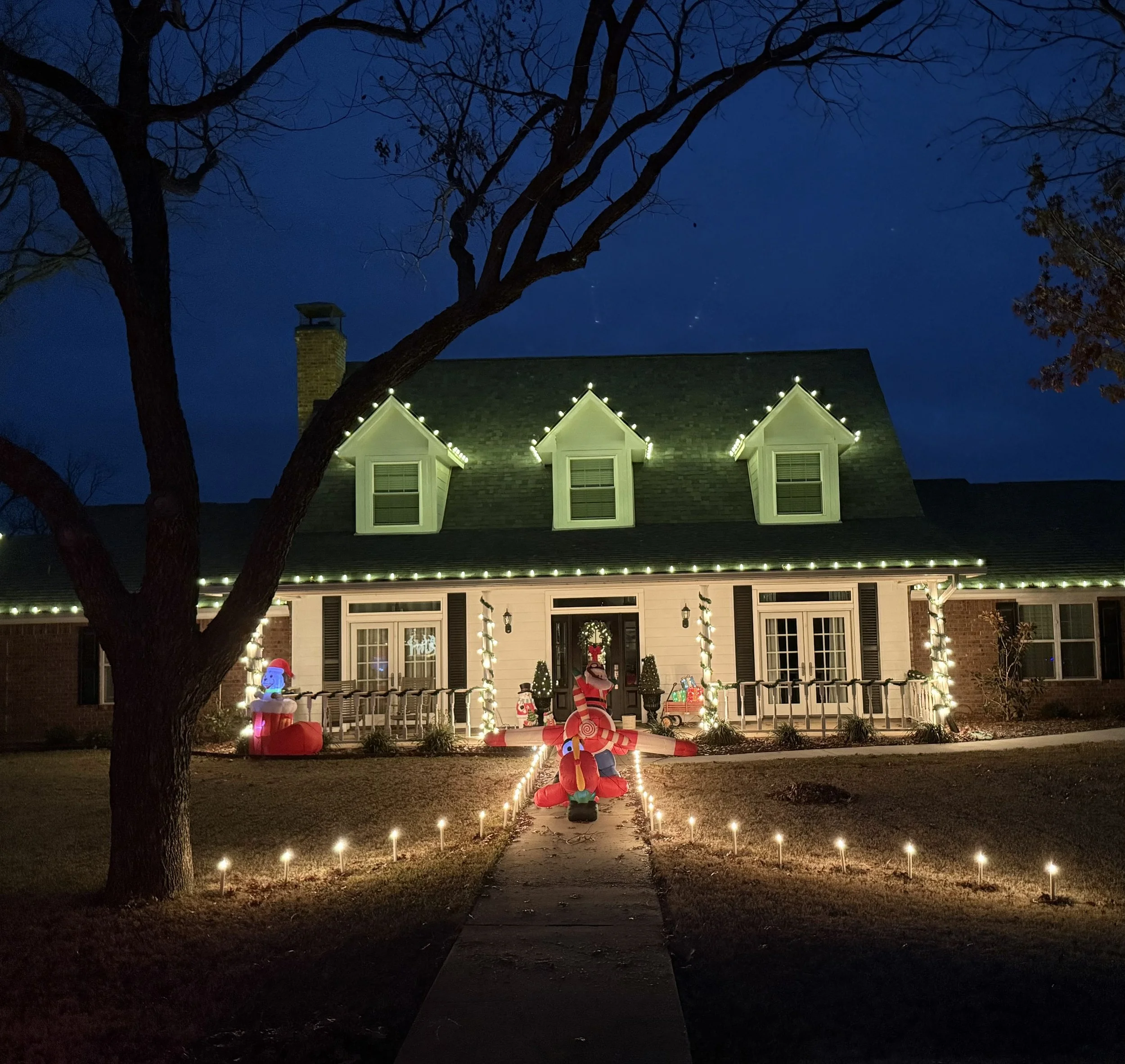 Christmas light installation with roofline and pathway lighting on a custom home in Granbury, Texas at Pecan Plantation. Holiday lighting by Bearded Elf Co.