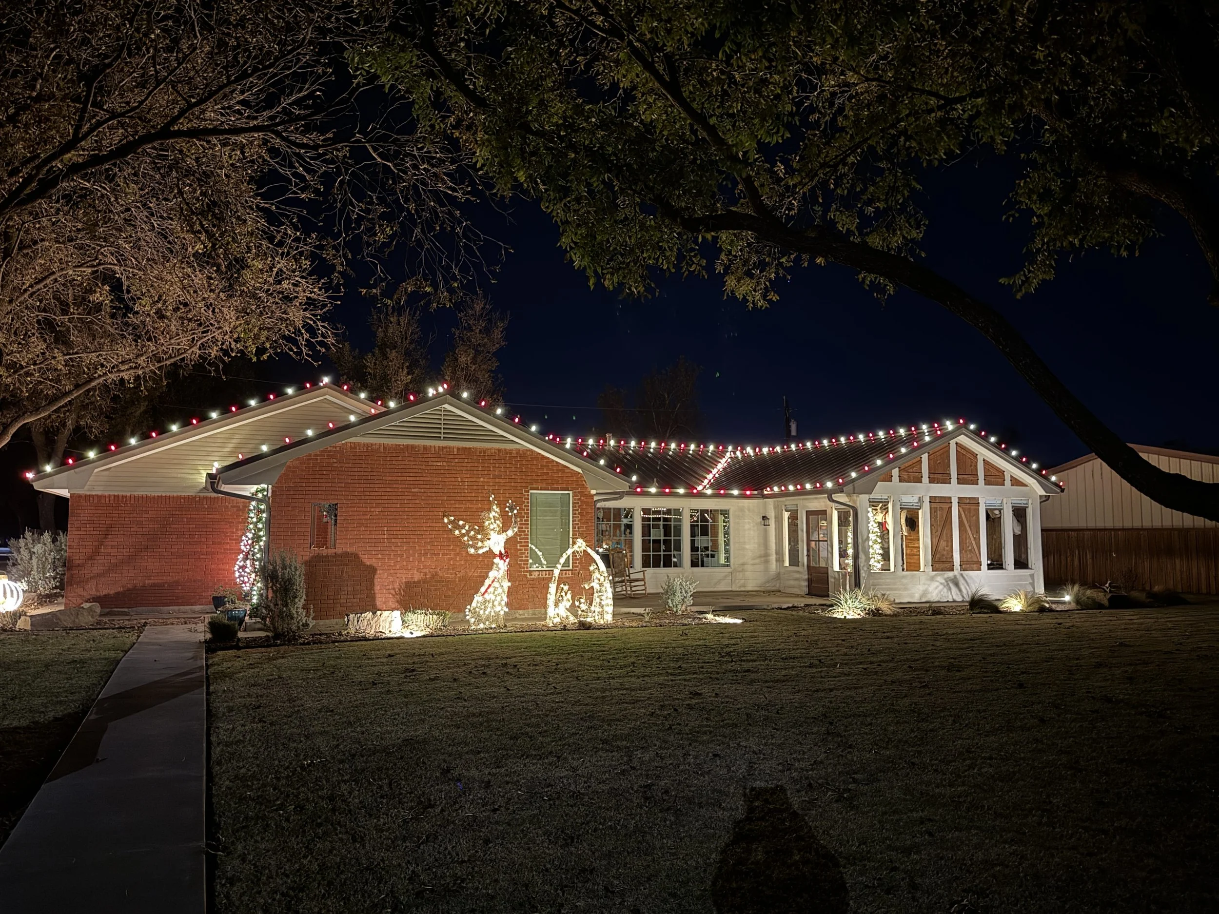 Residential Christmas light installation in Stephenville Texas. Red, and warm white roofline lighting and entrance lighting by Bearded Elf Co.