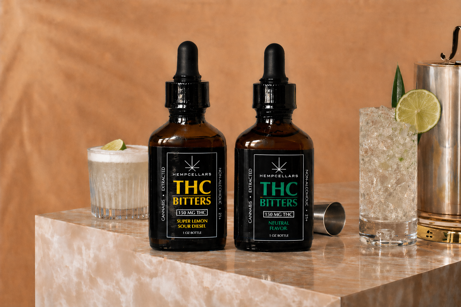 Two bottles of THC bitters, one labeled 'Super Lemon Sour Diesel' and the other 'Neutral Flavor,' are placed on a marble surface. To the left is a glass with a drink garnished with a lime wedge, and to the right is a tall glass with a clear patterned drink, garnished with lime slices and a leaf. Behind, there is a metallic cocktail shaker.