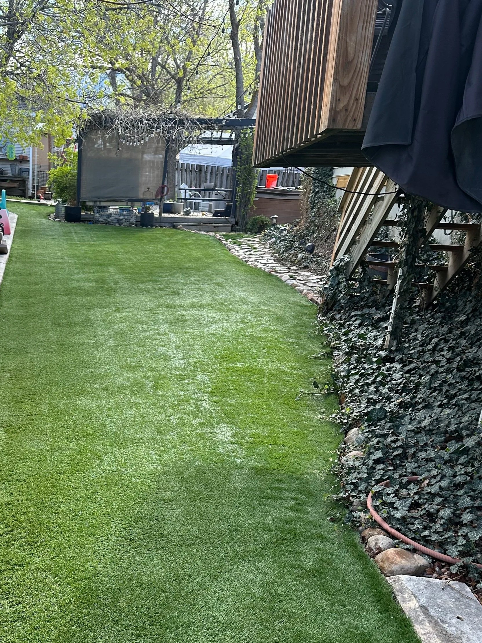 Professional artificial turf cleaning and power brushing results for a residential backyard in Utah.