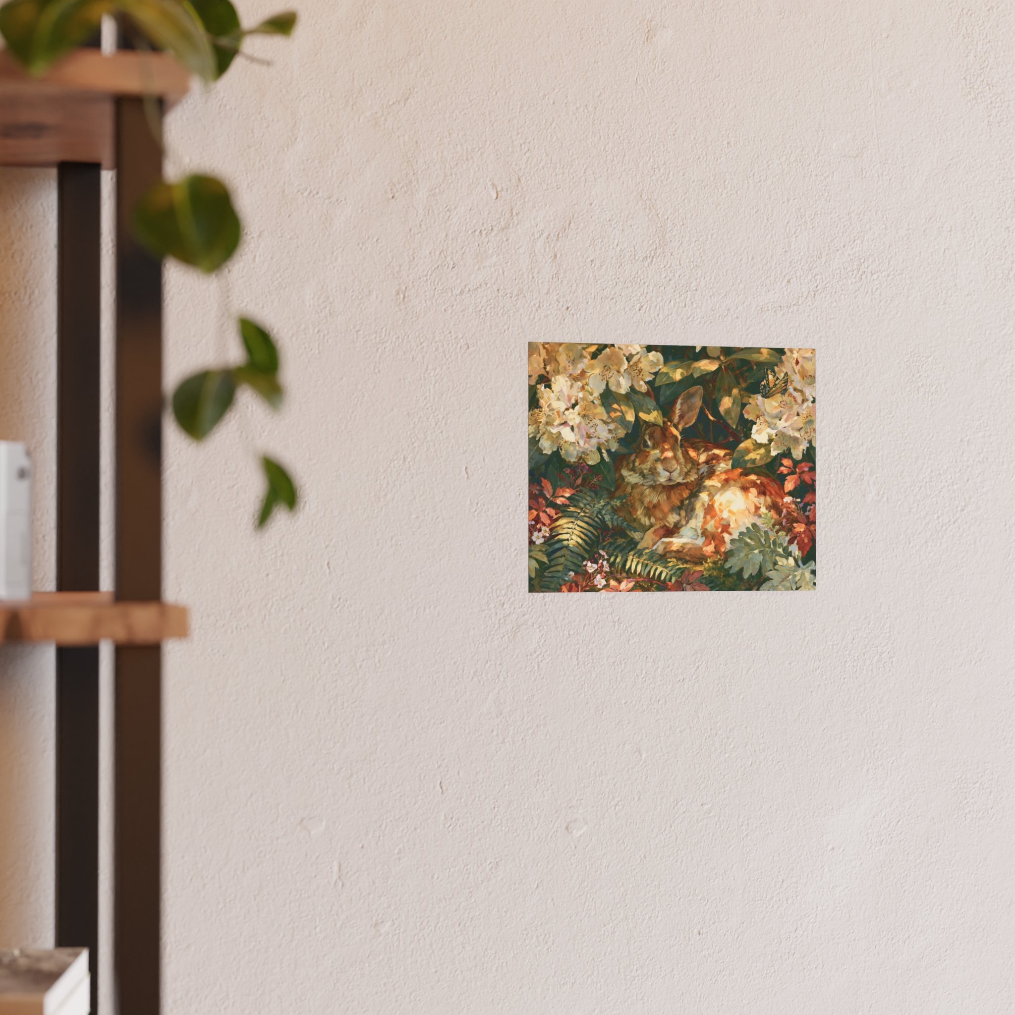 Rabbit in the Rhododendron 10 x 8 art print displayed on a light wall beside a wood shelf and green plant