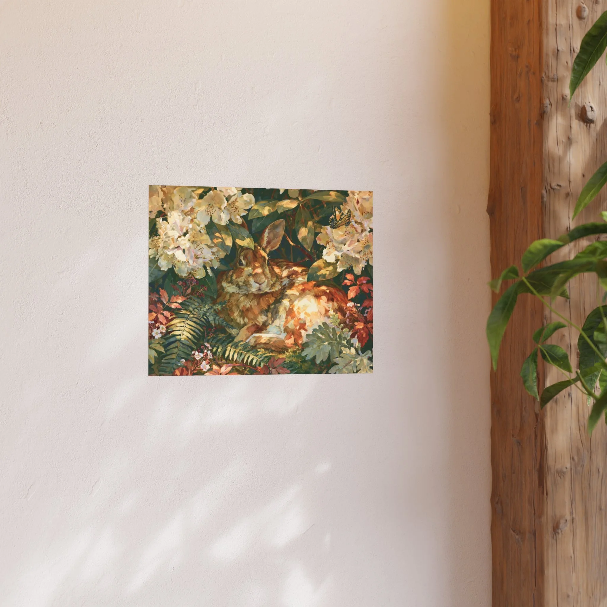 Rabbit in the Rhododendron 20 x 16 art print displayed on a light wall beside a wood shelf and green plant