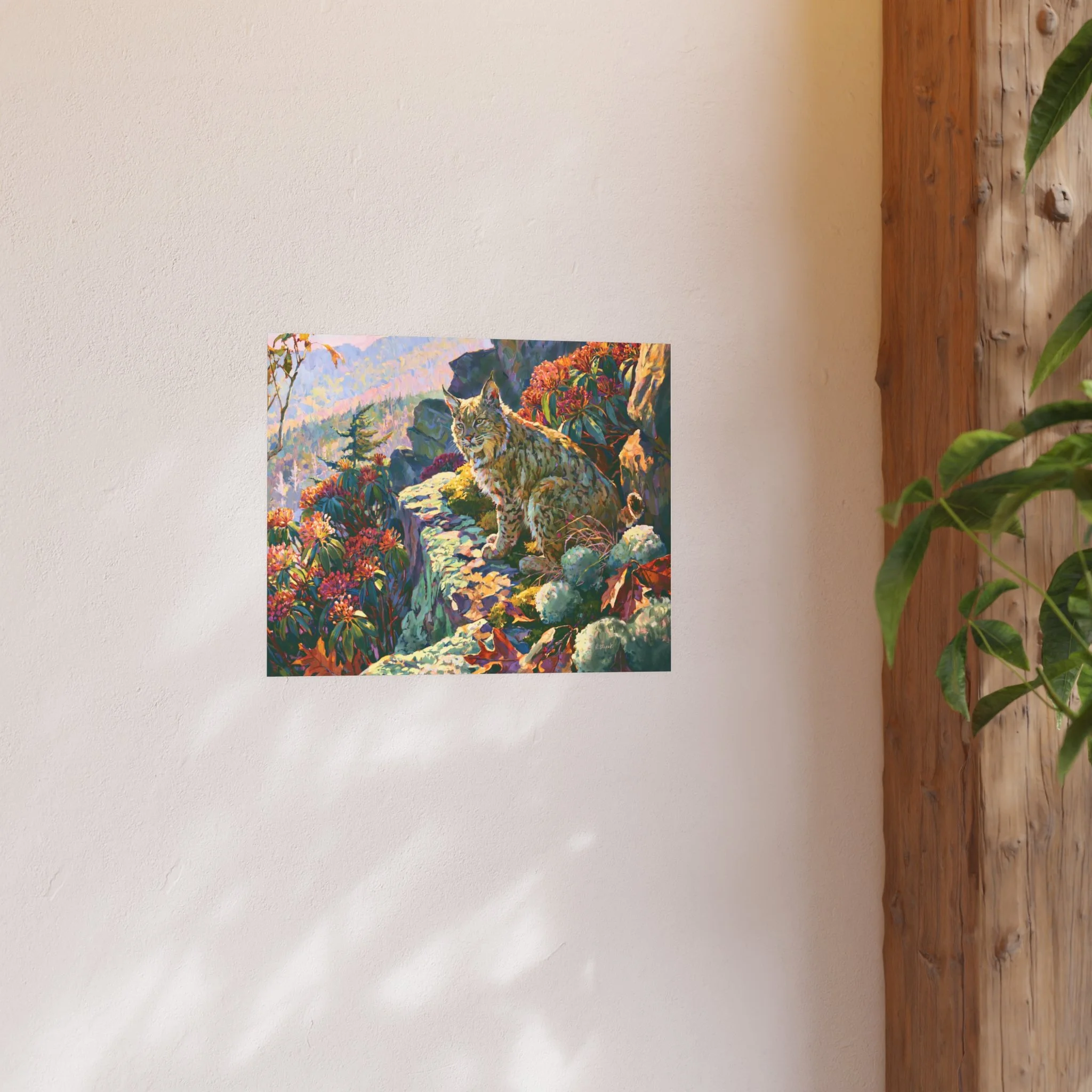 Wildcat Over the Gorge 20 x 16 bobcat art print displayed on a light wall beside a wood beam and green plant