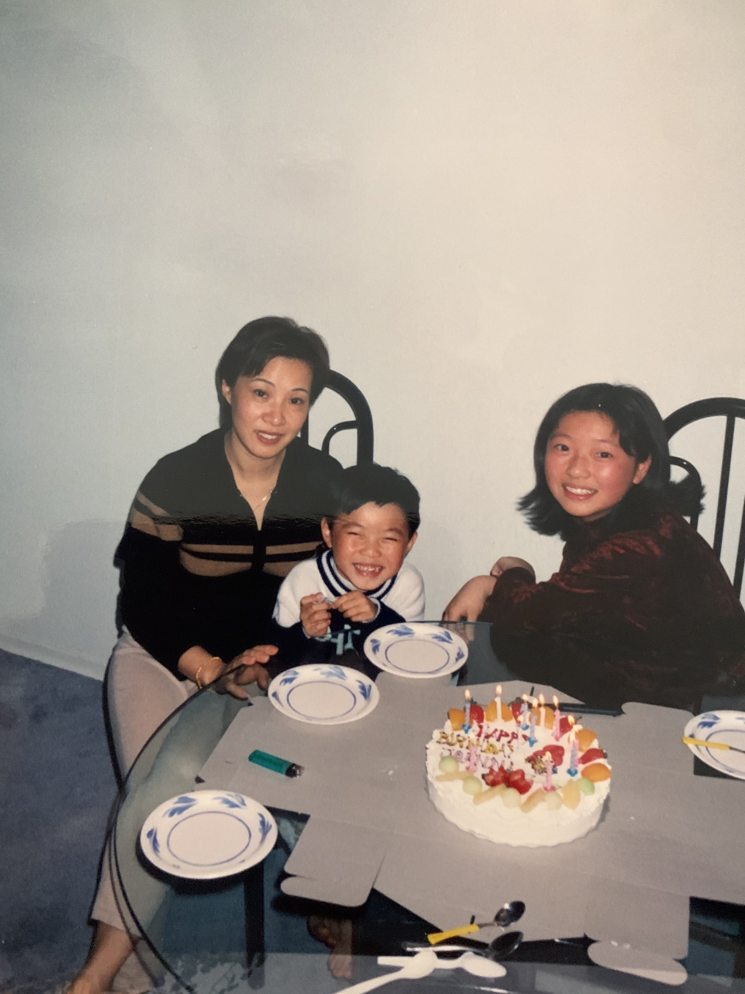 Archival photo featuring a young AJ Harley celebrating a birthday with their mum and sister.