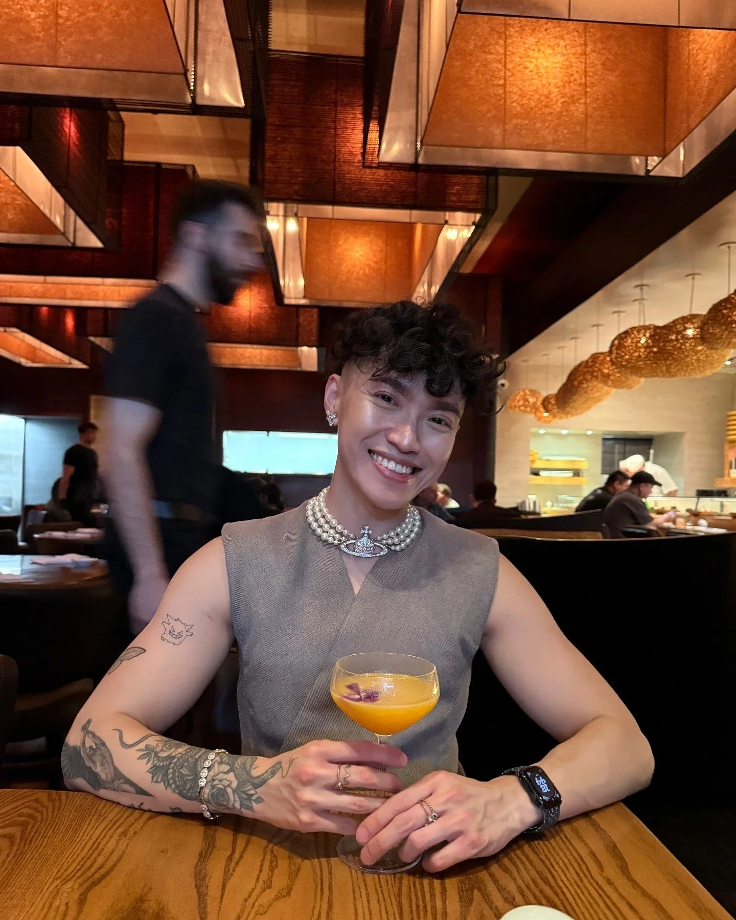 AJ Harley seated at a bar wearing a Vivienne Westwood sheer top and pearl necklace at Nobu West Hollywood.
