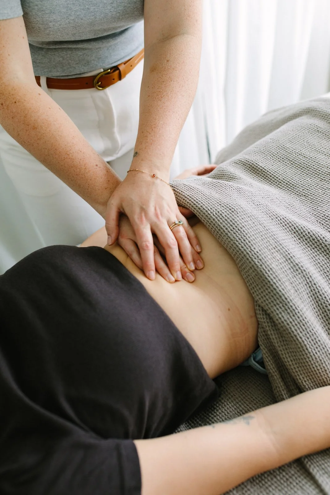 A person receiving an abdominal massage as part of Mercier therapy