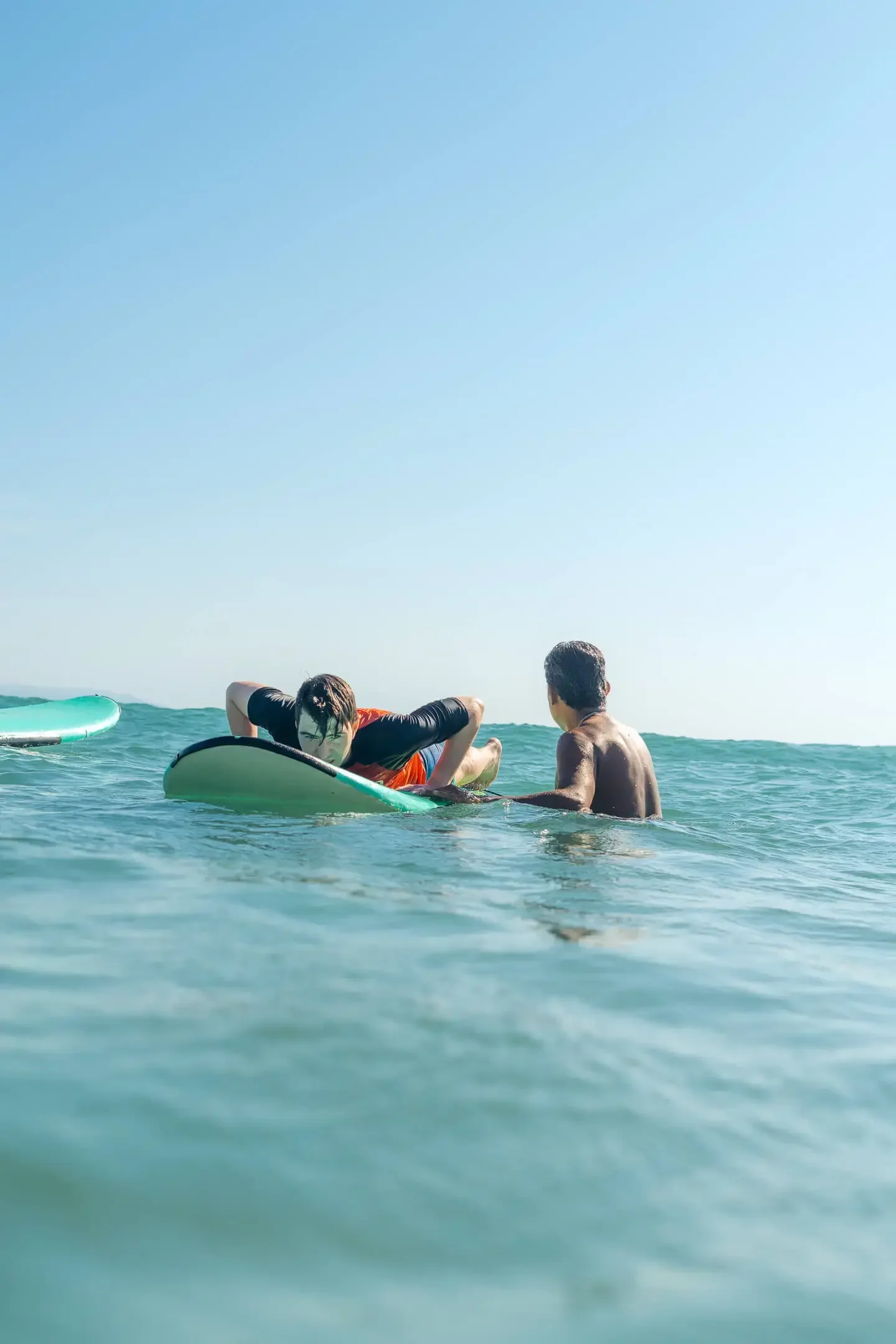 surf lesson Sayulita Mexico — instructor and student on surfboard | Marea Surf School