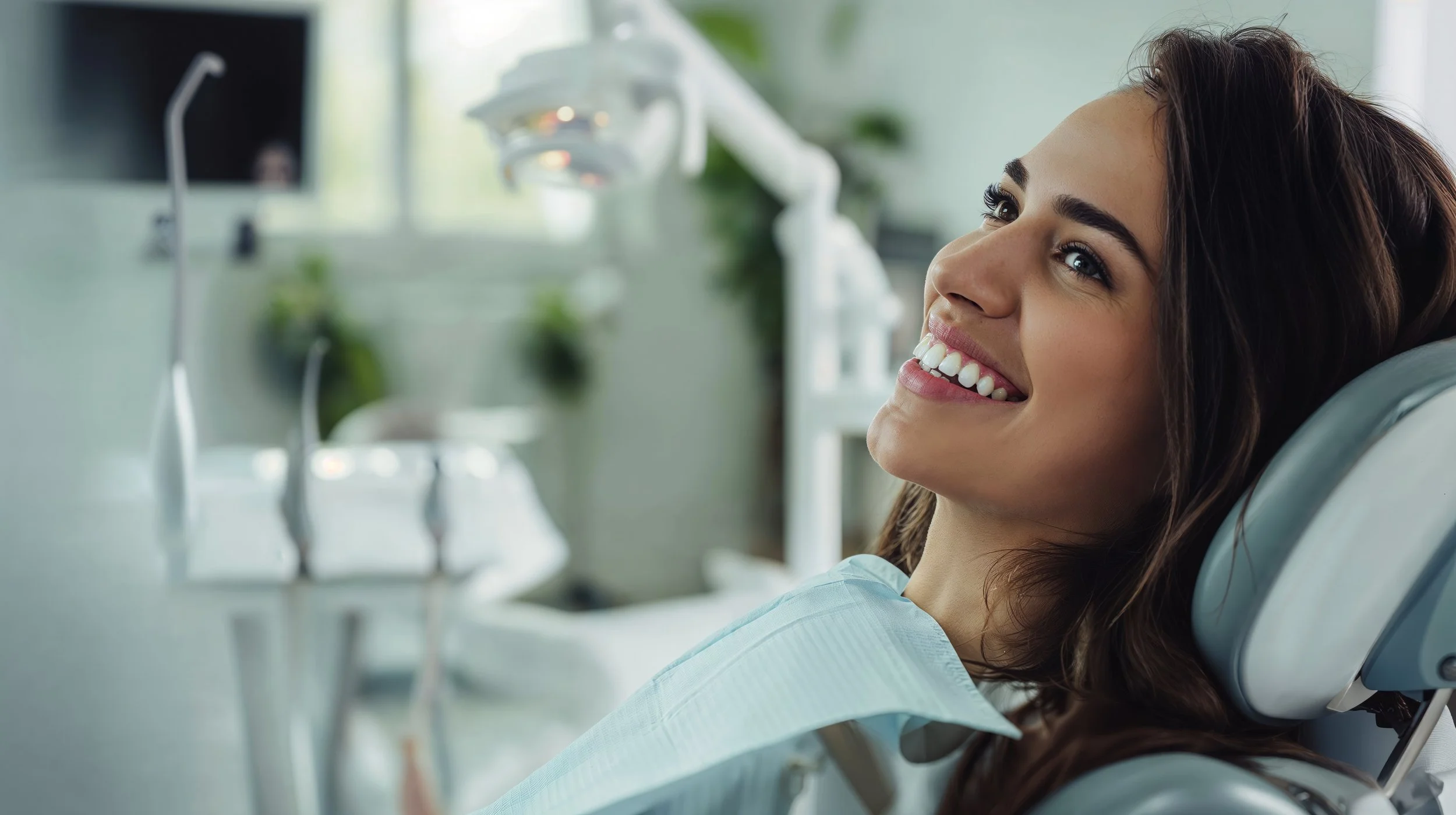 Woman smiling in a dental chair during consultation