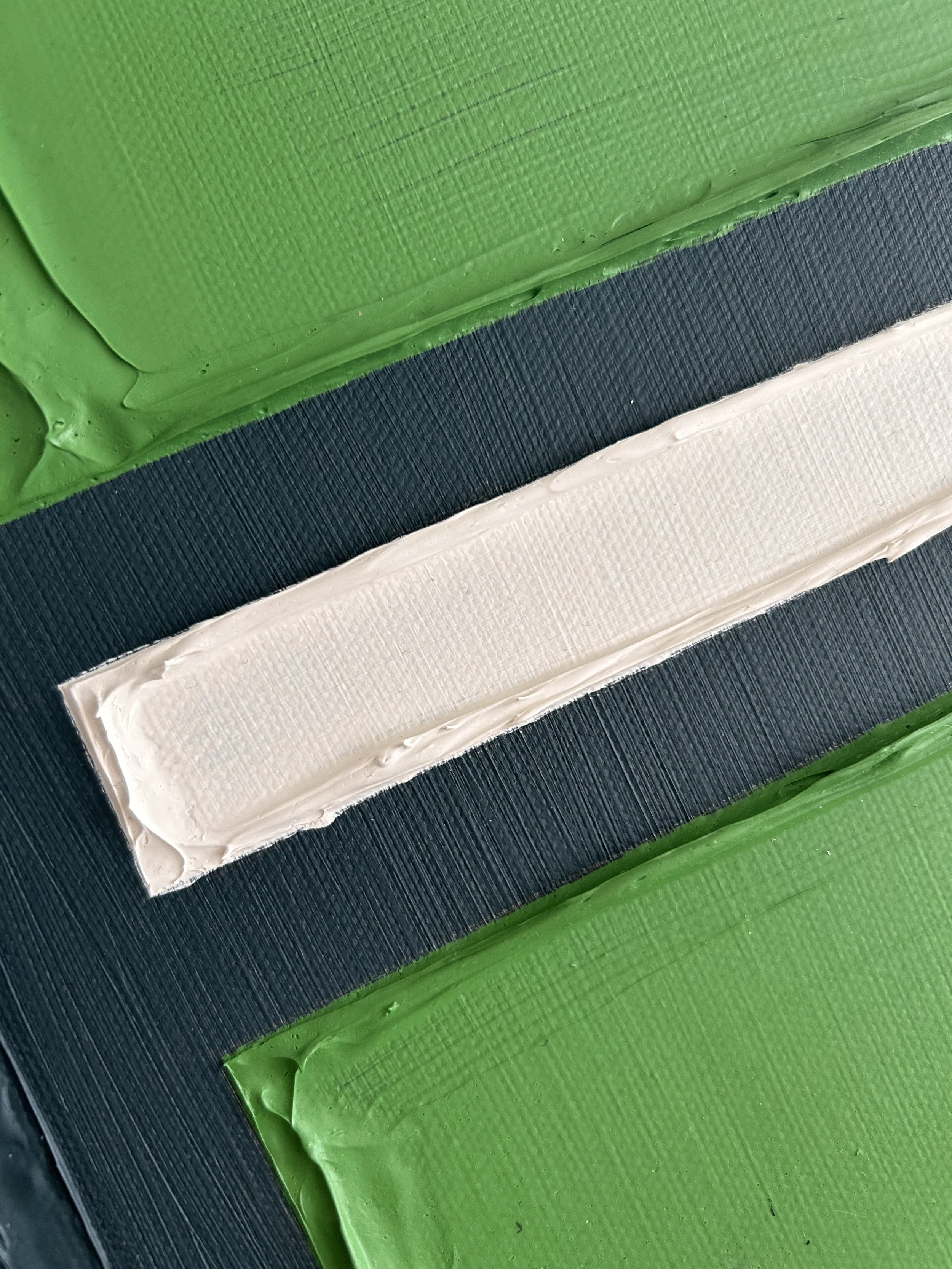 Close-up of a hockey or sports rink with green, navy blue, and white colored ice surface markings.