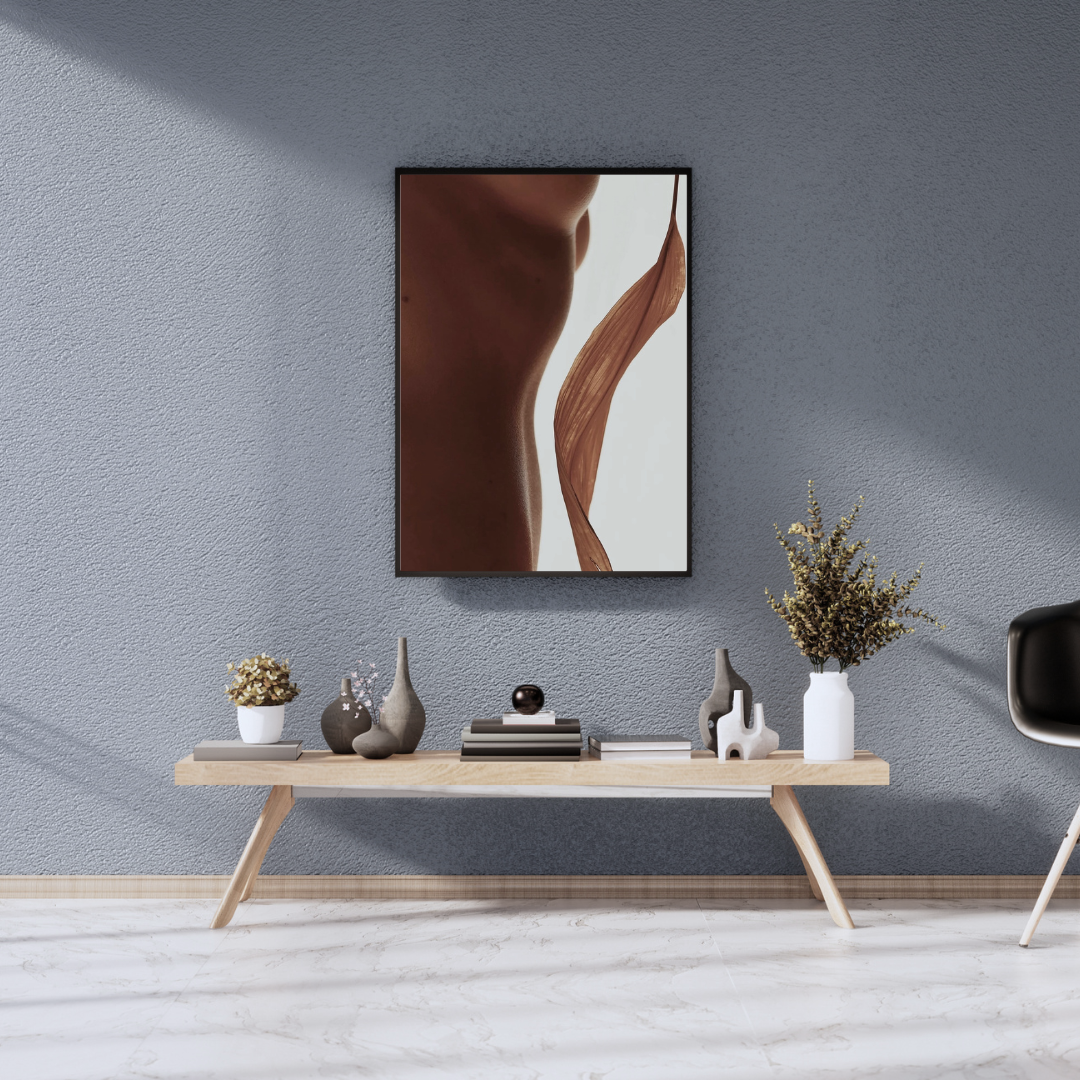 Decorative interior with a console table holding vases and books, large abstract art piece on a textured blue wall, and a black modern chair, set on a white marble floor.