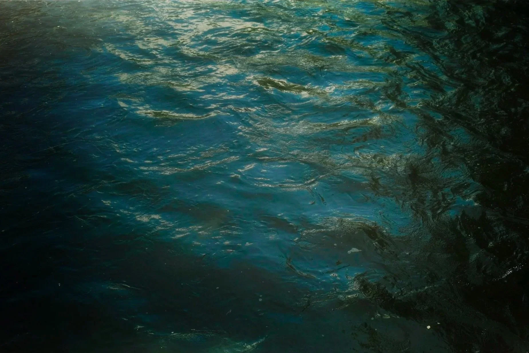 Close-up view of a body of water with ripples and reflections, possibly in a lake or ocean.