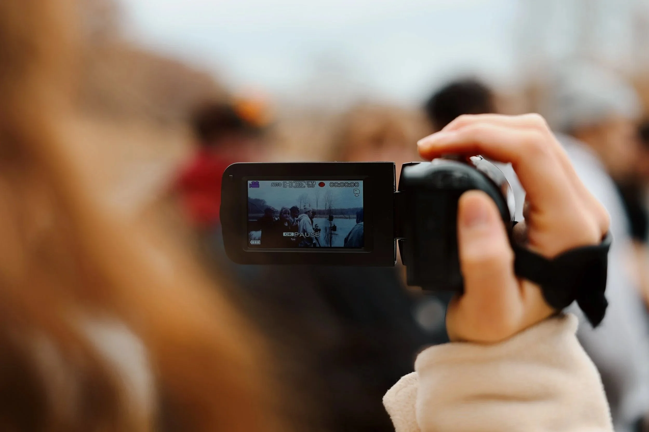 Person or group holding a camera and taking a photo at an event or gathering