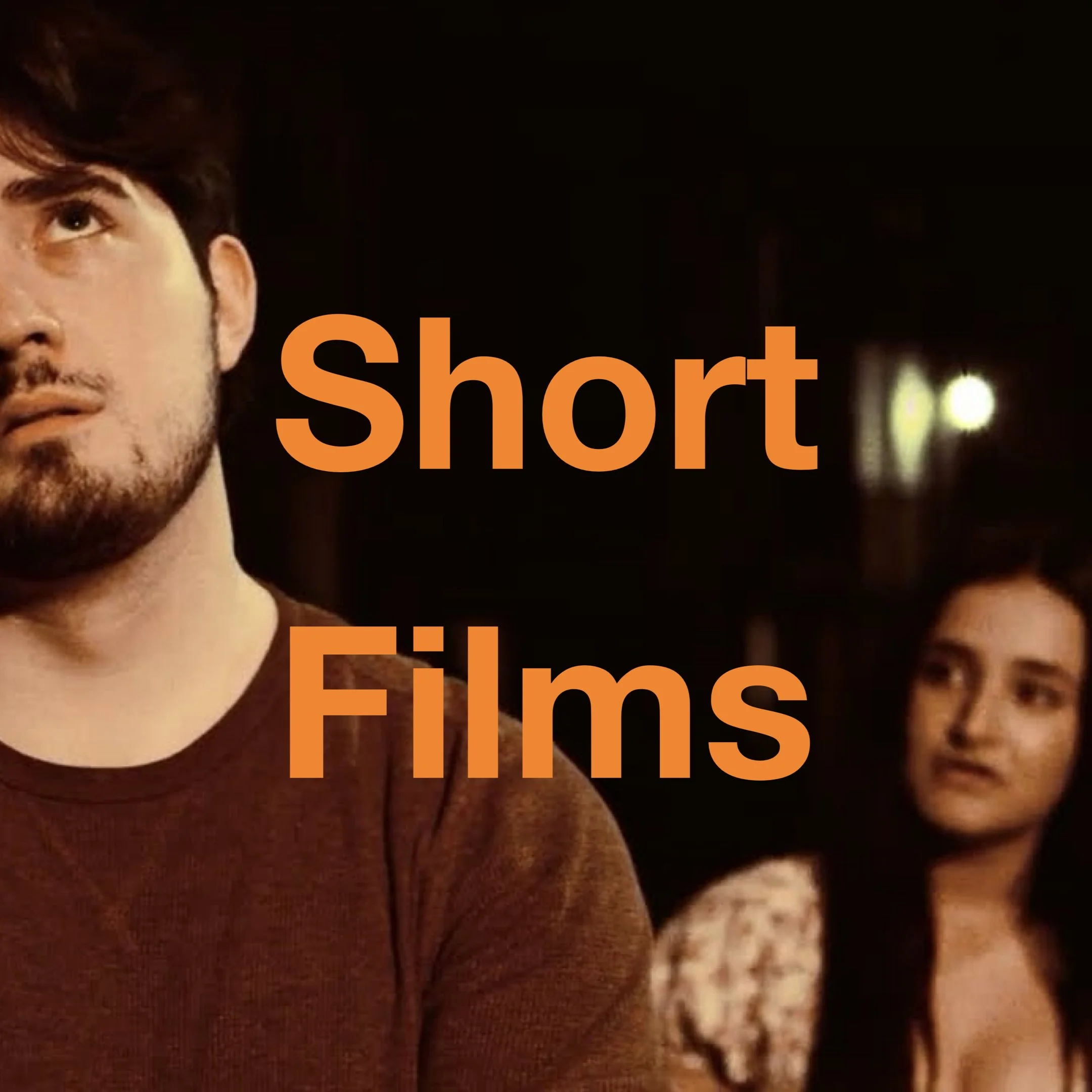 Close-up of a man's face and part of a woman's face, with overlaid orange text that says 'short'.