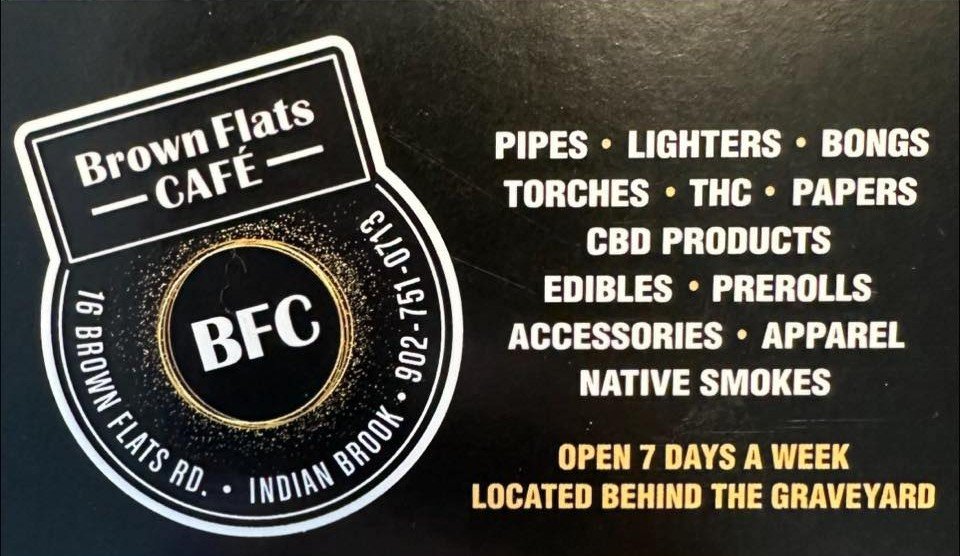 Sign for Brown Flats Café listing various products sold including pipes, lighters, bongs, torches, THC, papers, CBD products, edibles, prerolls, accessories, apparel, native smokes. Located at 16 Brown Flats Rd, Indian Brook. Open 7 days a week, behind the graveyard.