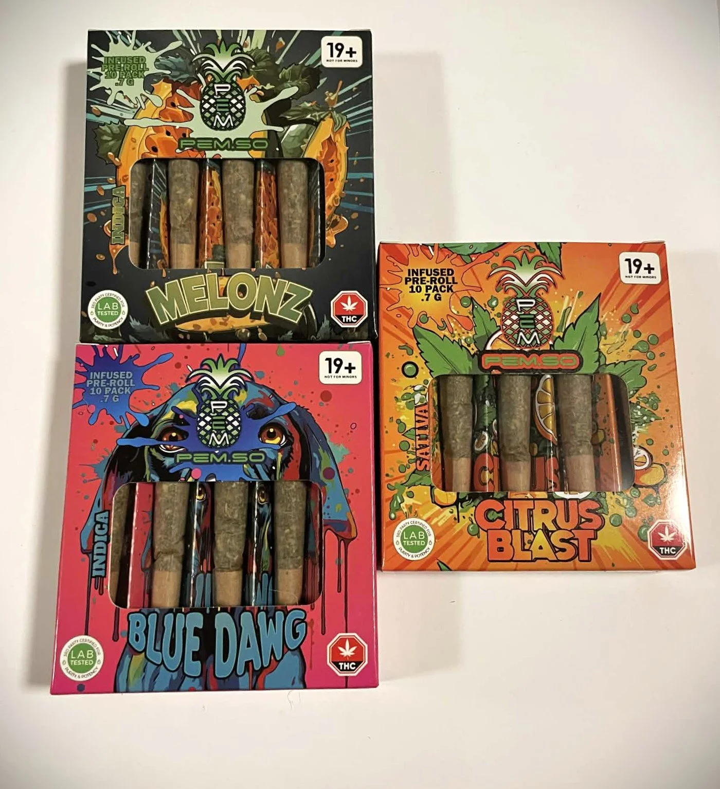 Three boxes of cannabis pre-rolls with colorful, graphic designs on a white surface. The boxes are labeled Melonz, Blue Dawg, and Citrus Blast, each containing ten pre-rolls with 0.7 grams of cannabis. The packaging features lab tested and THC warning labels.