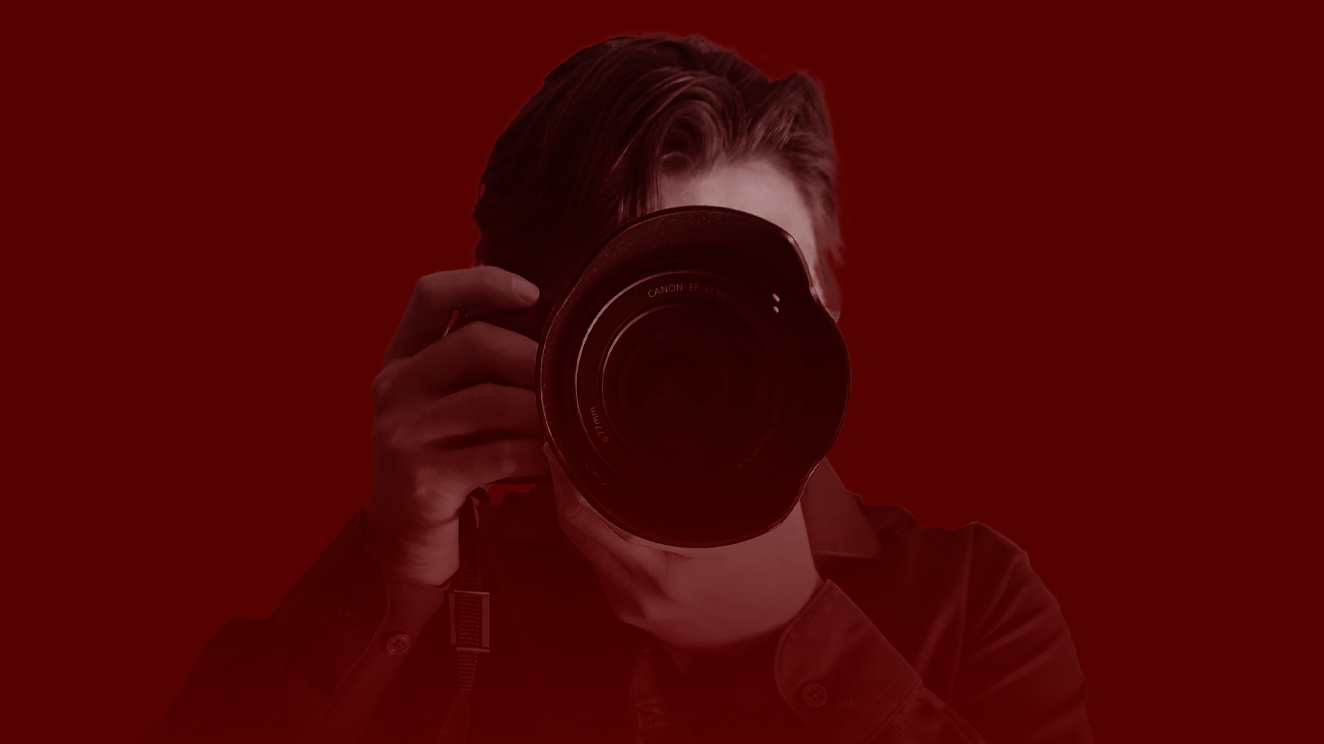 Person holding a camera, with a red background.