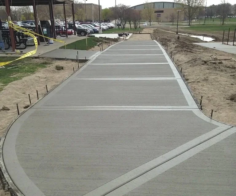 Concrete walkway installation by Concrete Concepts & Exteriors showcasing skilled craftsmanship as a crew member smooths freshly poured concrete to create a clean, durable, and long-lasting finish
