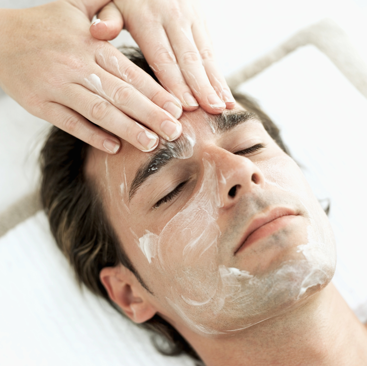 A man receiving a professional skin treatment in a clinical setting.