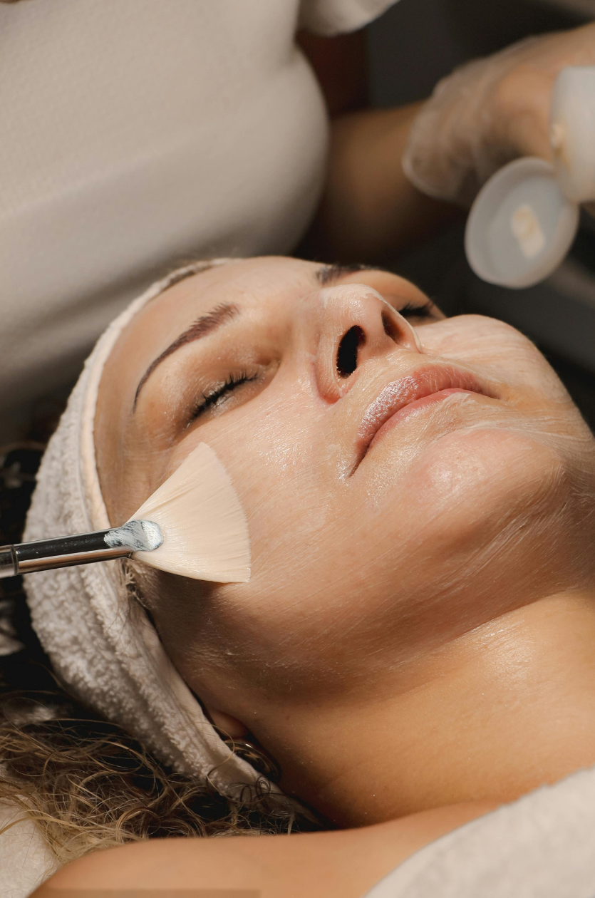 Client receiving a professional facial treatment with a treatment mask being applied.