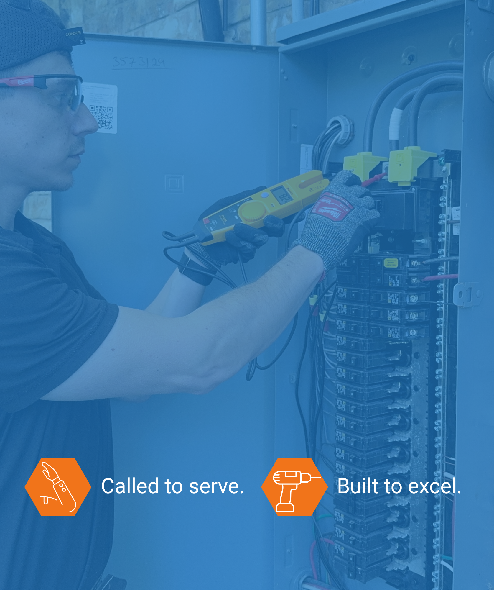 A man wearing safety glasses and gloves is using a digital multimeter to test connections inside an electrical panel with multiple circuit breakers.