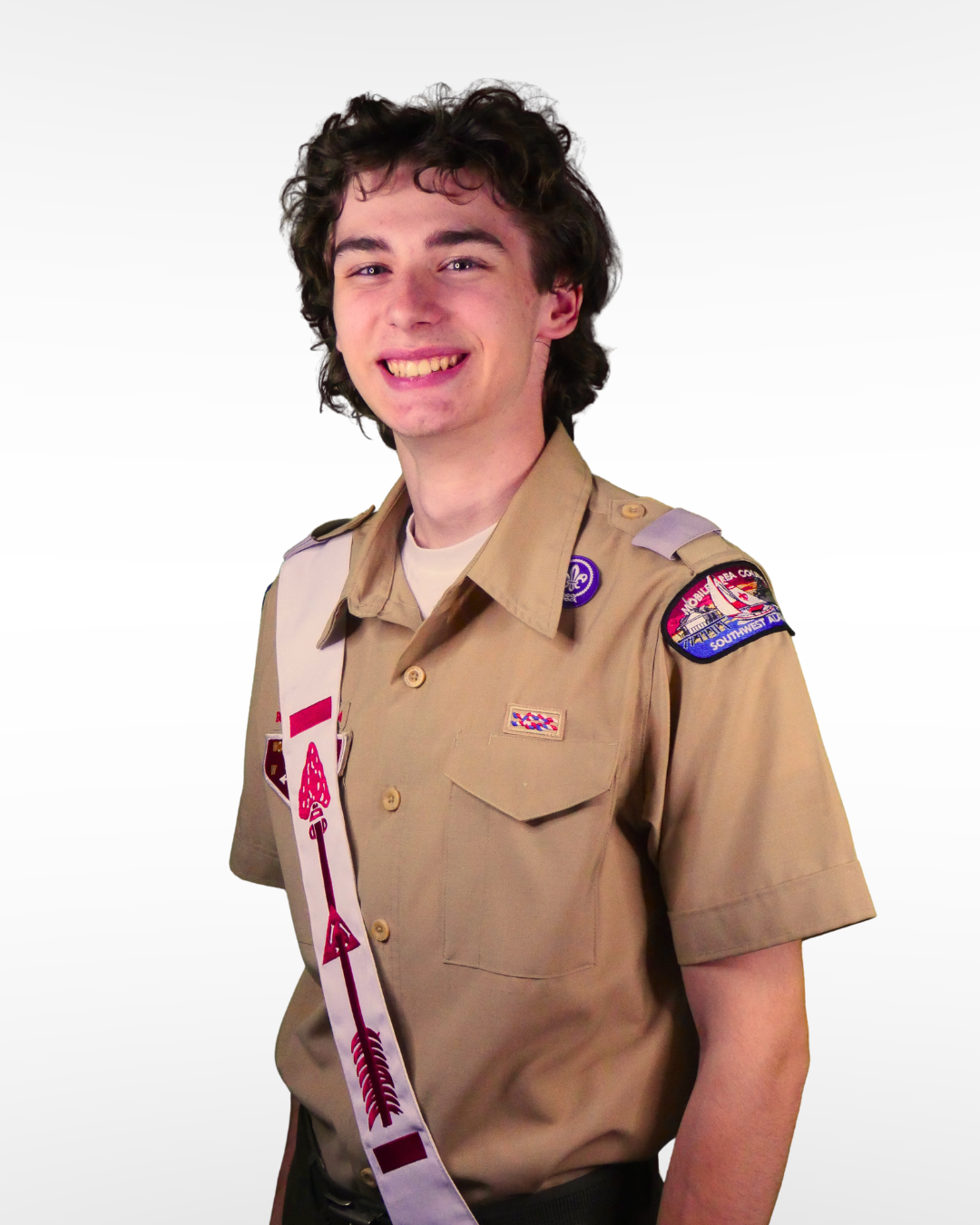 A young person in Boy Scout uniform smiling at the camera.