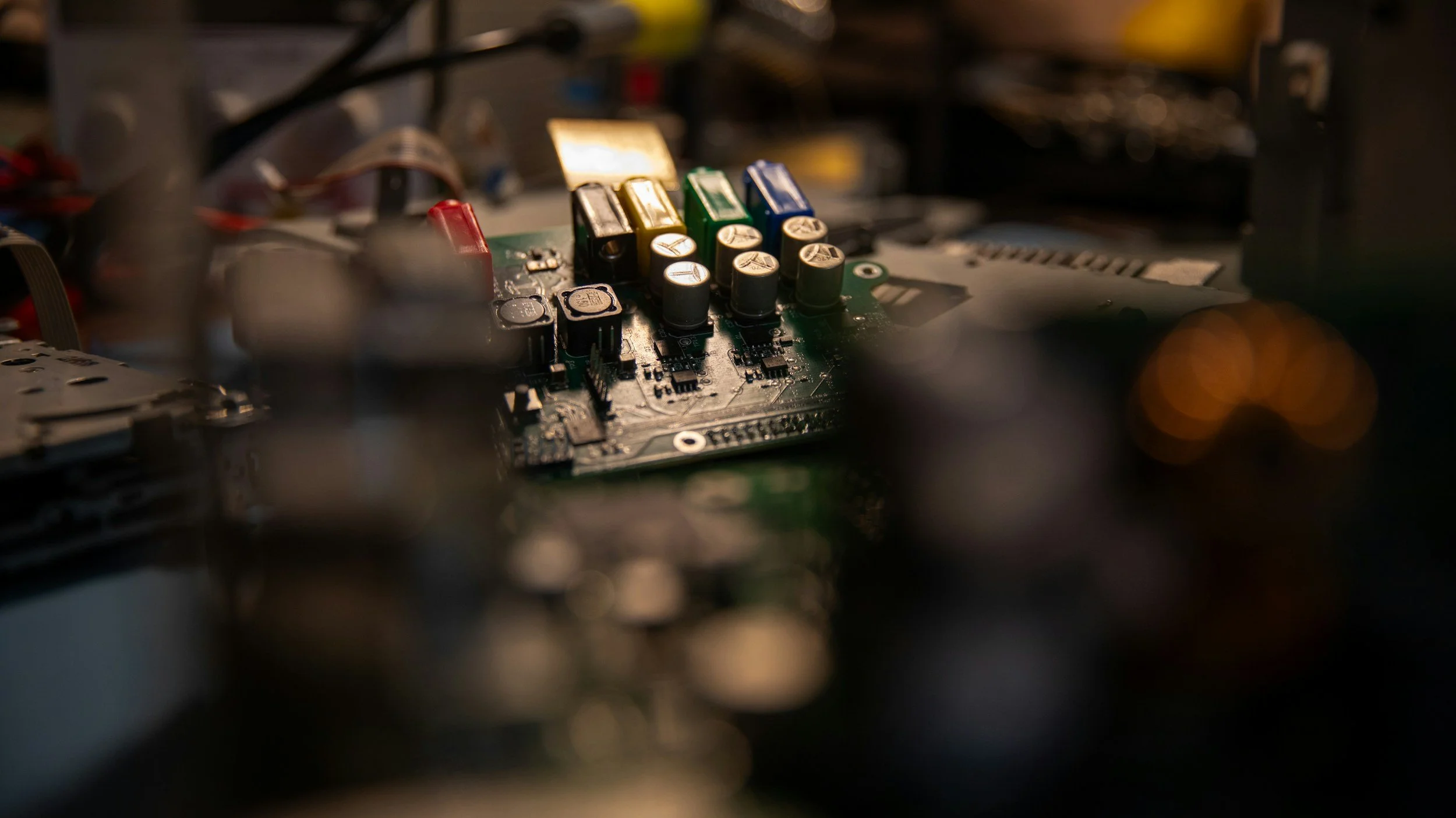 Close-up of a computer circuit board with capacitors and colored components, likely inside a device or electronic equipment.