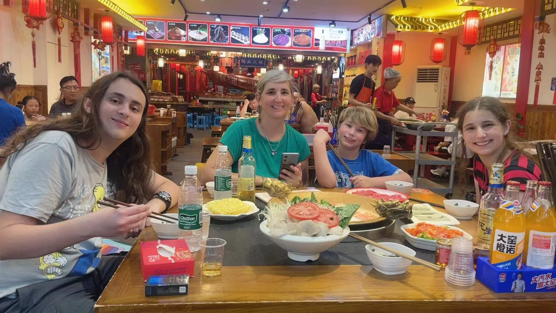 A family from London sharing a traditional spicy hotpot meal at a restaurant in Chongqing during a private family tour