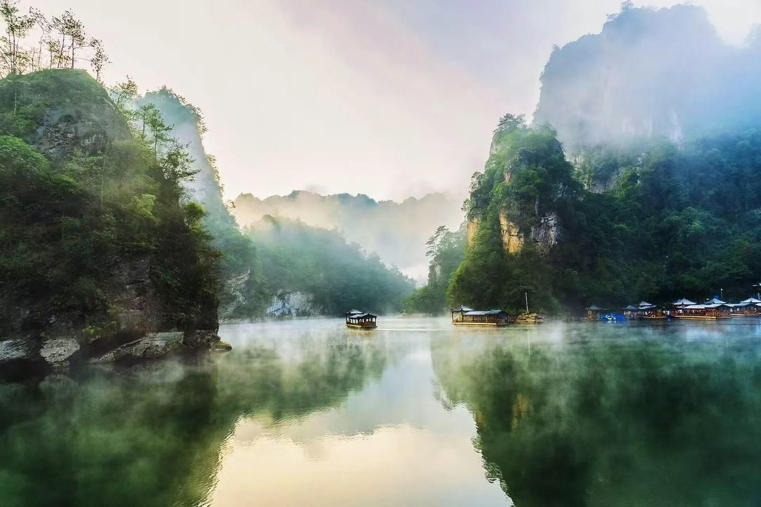 A boat crossing Baofeng Lake beneath sandstone cliffs, Zhangjiajie
