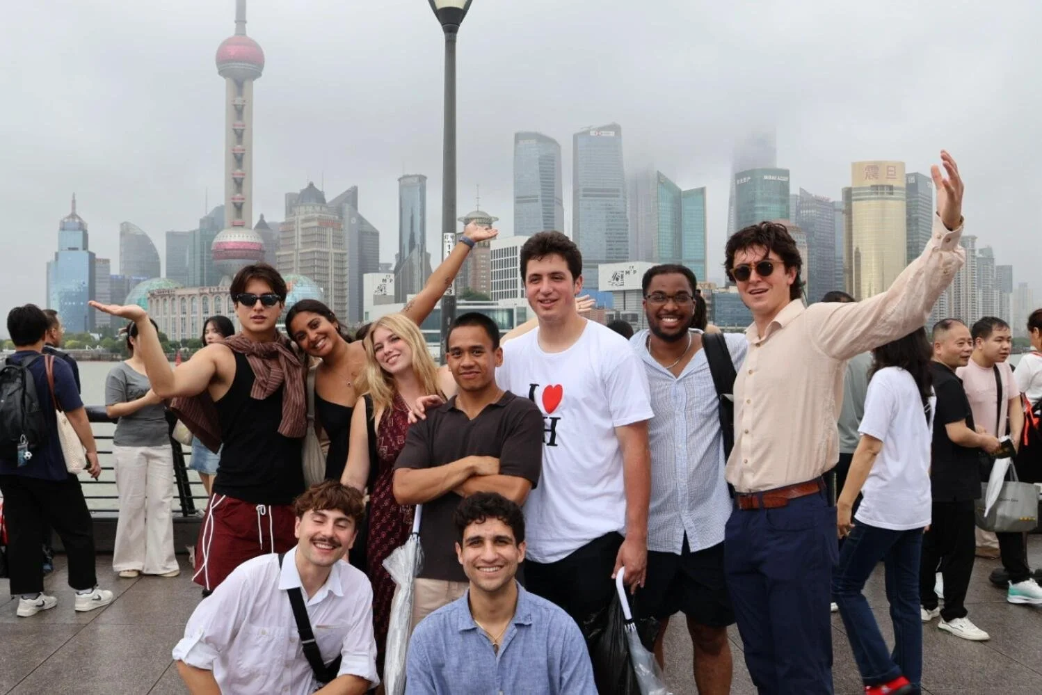 A group of employees from a French foreign trade company posing in front of the Shanghai skyline and Oriental Pearl Tower during a private city tour