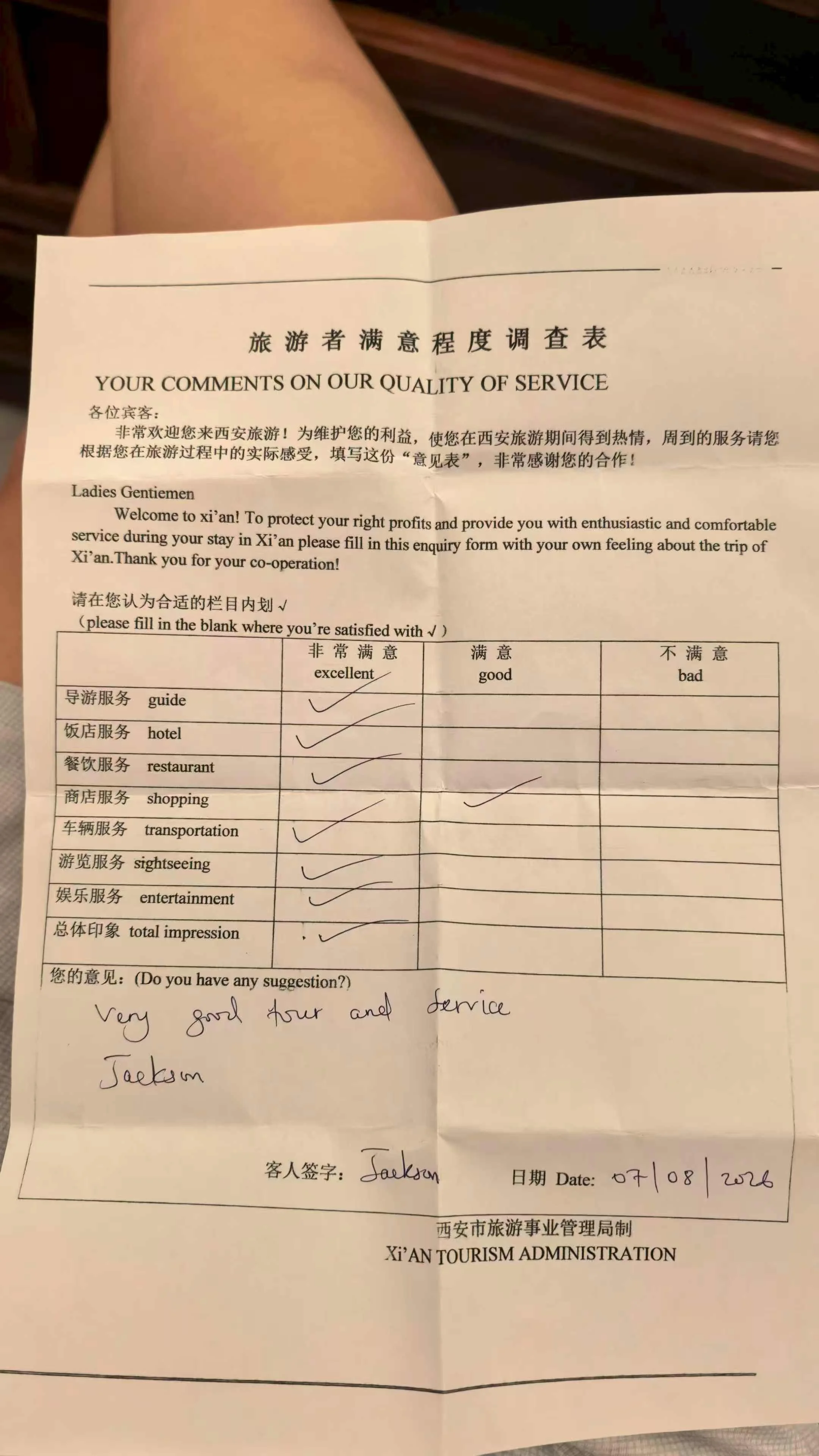 A handwritten Chinese tourism service quality evaluation form with "Excellent" checkmarks for the guide, driver, and hotel service