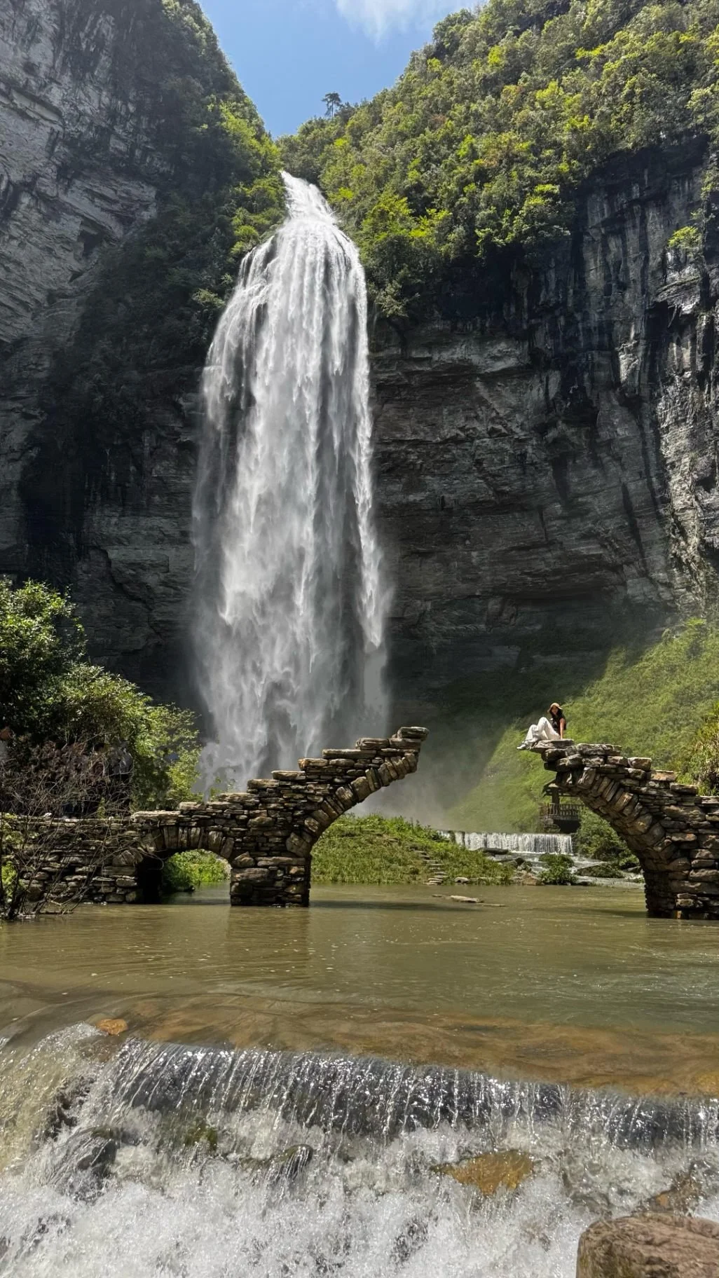 Liusha Waterfall falling 216 metres into the Dehang canyon, framed by a   stone arch bridge, Xiangxi, Hunan