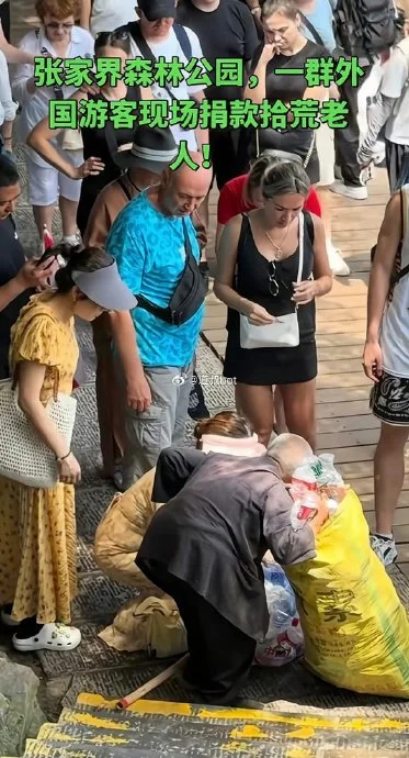 A screenshot from the phone video that started the episode: foreign tourists hand cash to an elderly bottle collector on a trail in Zhangjiajie National Forest Park, around 20 August 2026. The footage is real. The story attached to it was not.