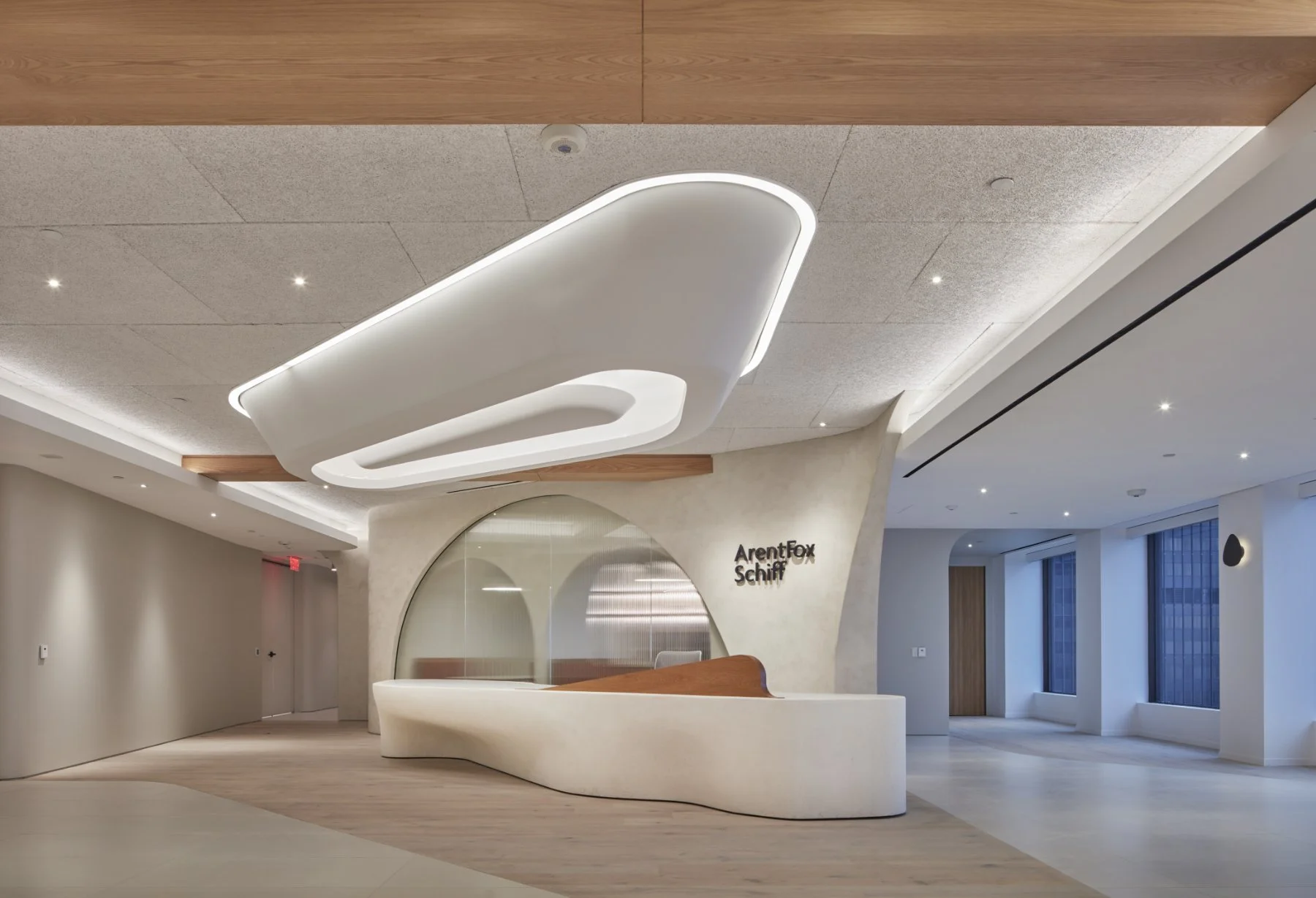 Modern reception area with a white curved desk and a large abstract ceiling light fixture, part of the Arent Fox Schiff office lobby.