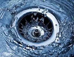 Close-up of a drain with water swirling around it