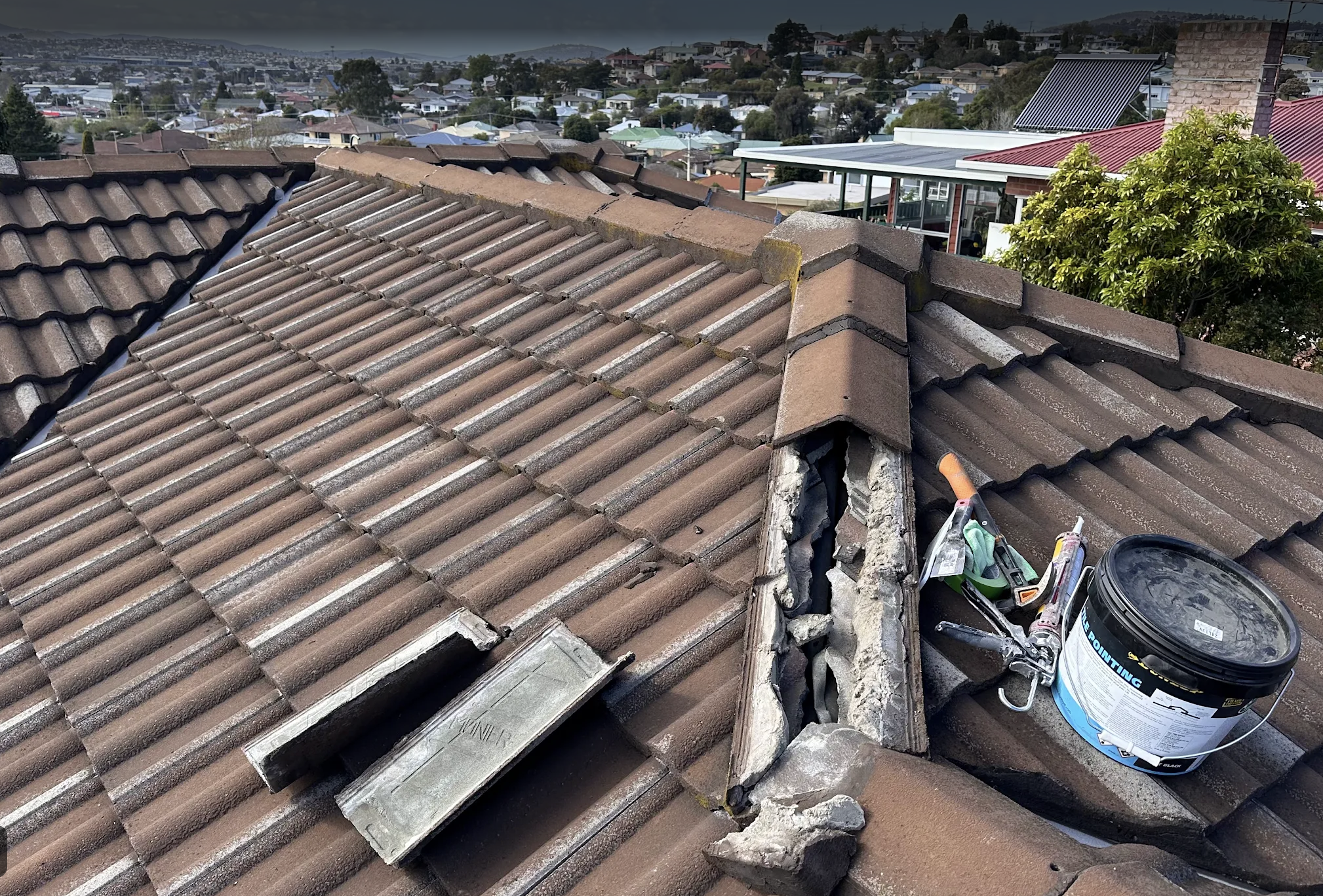 Roof leak repair on a tiled roof in Hobart, with roof tiles removed to inspect and repair the damaged area - TAS Roof & Gutter Cleaning