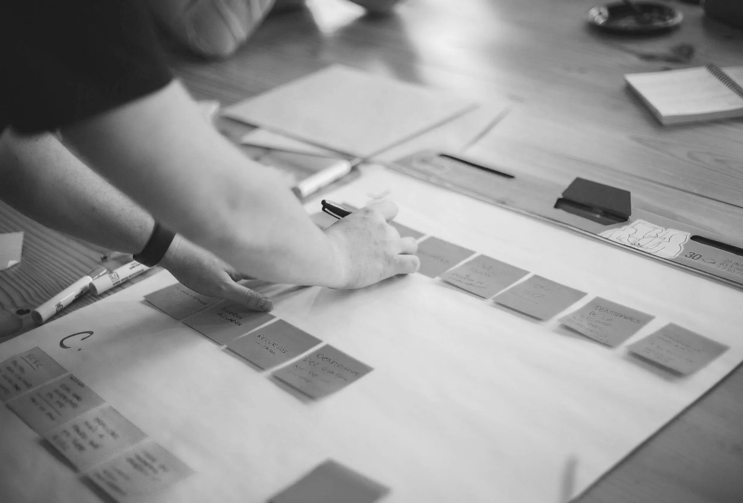 A person designing a flow process using sticky notes on a pad.