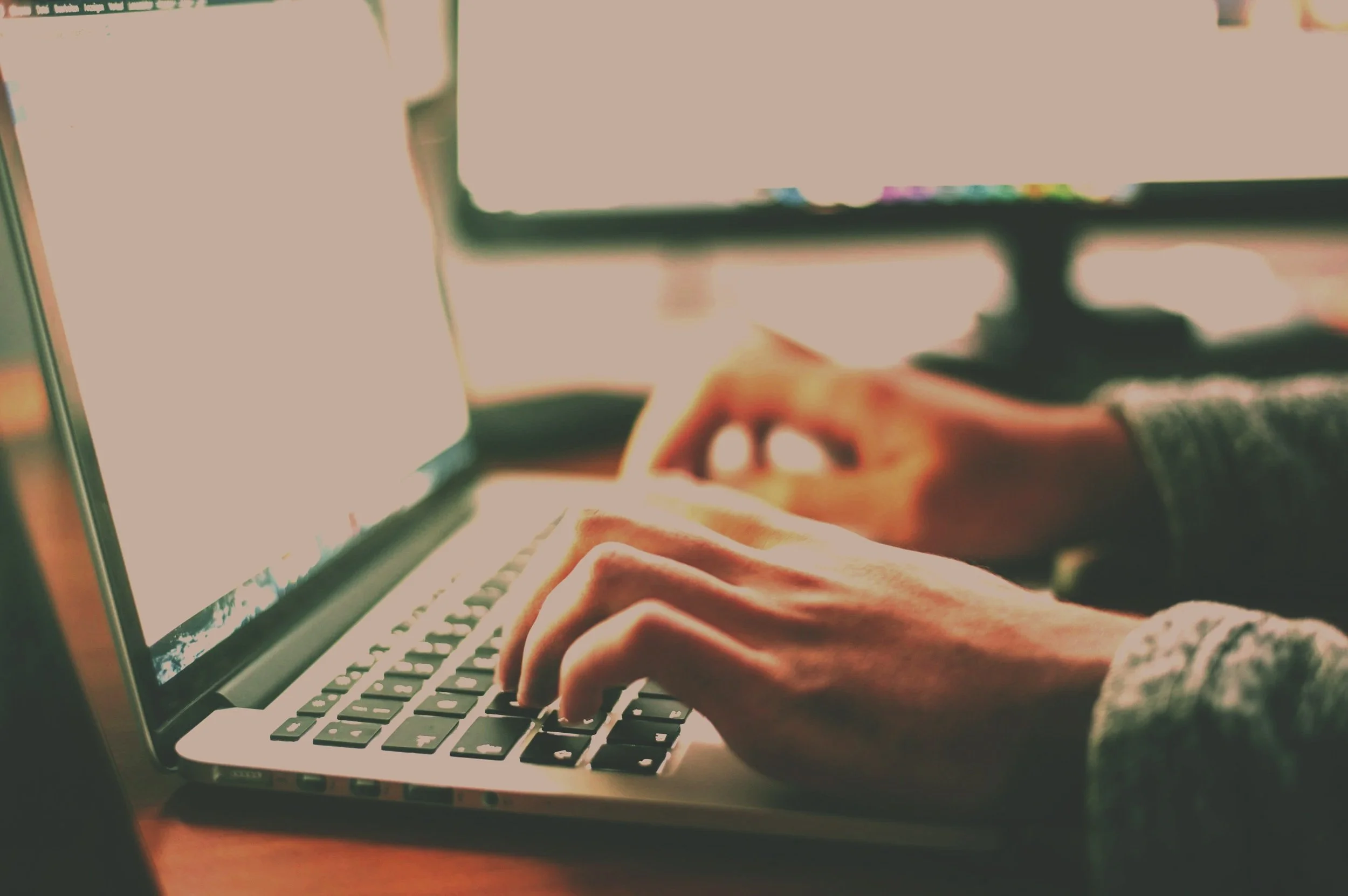 Close-up of a person typing on a laptop keyboard.