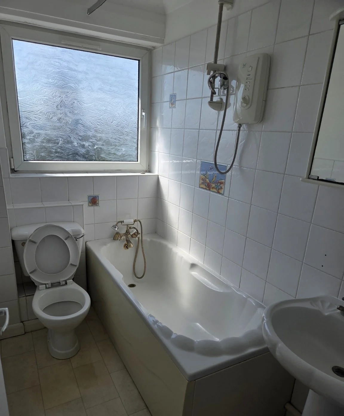 Gosport rental bathroom with white tiled walls, bath and toilet before refurbishment