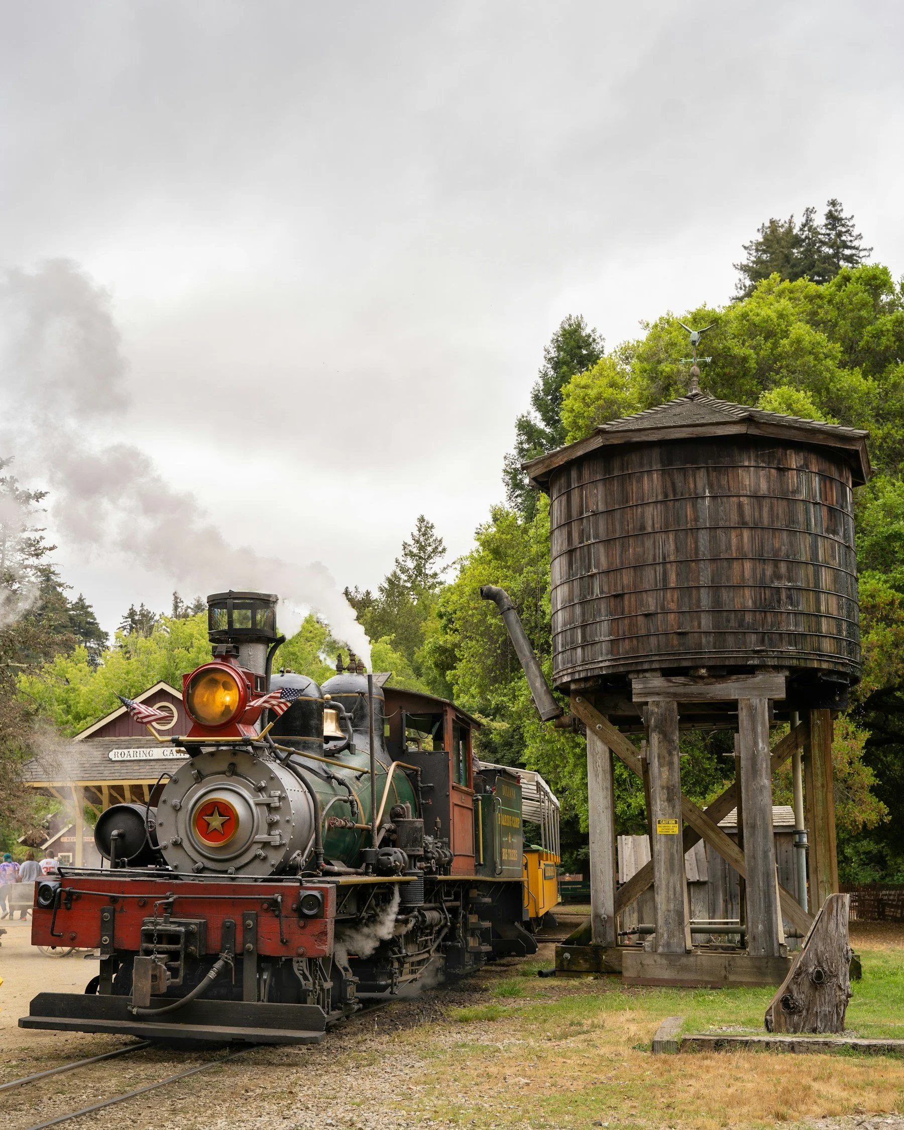 Historic steam locomotive beside the wooden water tower at Roaring Camp Railroads in Felton, California.